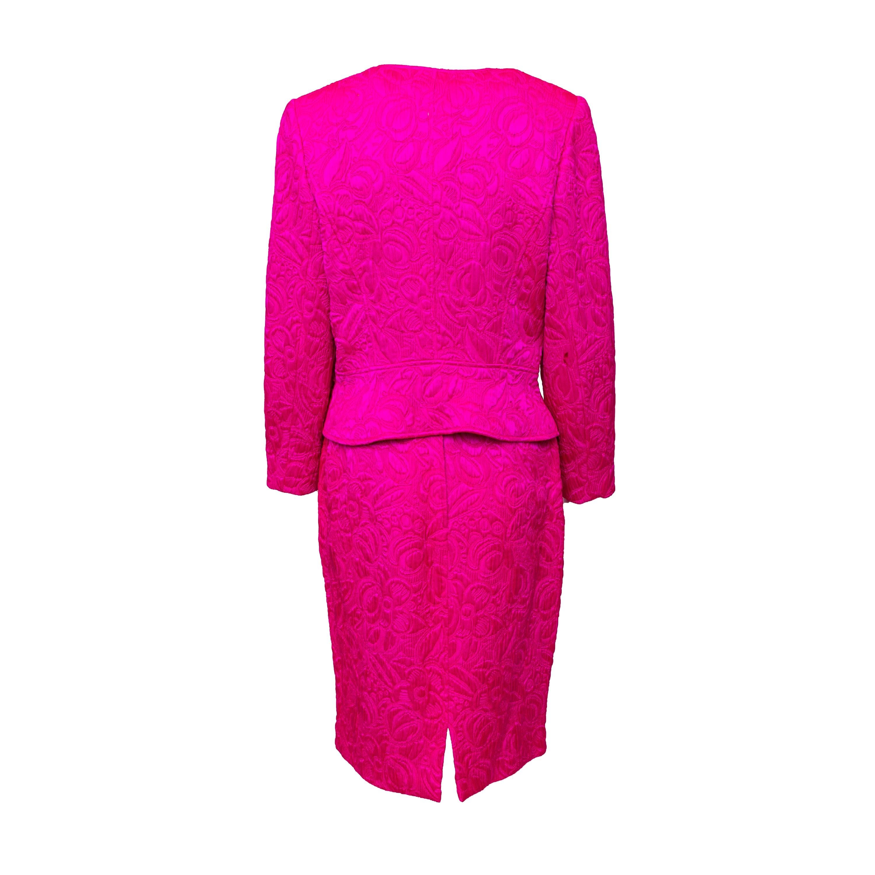 Ti presentiamo il set Ungaro degli anni '90, caratterizzato da un lussuoso tessuto in misto lana e seta in un vibrante rosa fucsia. Il set comprende un'elegante giacca con scollo a V e chiusura a due bottoni e un'elegante gonna midi, entrambe