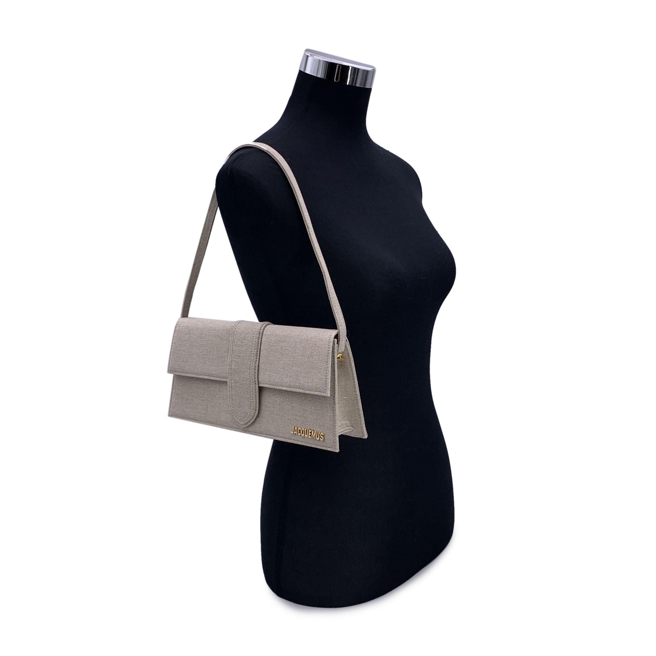 Discover the epitome of understated elegance with the Jacquemus Beige Linen Le Long Bambino Structured Box Bag. This exquisite piece, crafted from luxurious beige linen, perfectly embodies the minimalist yet sophisticated design that Jacquemus is