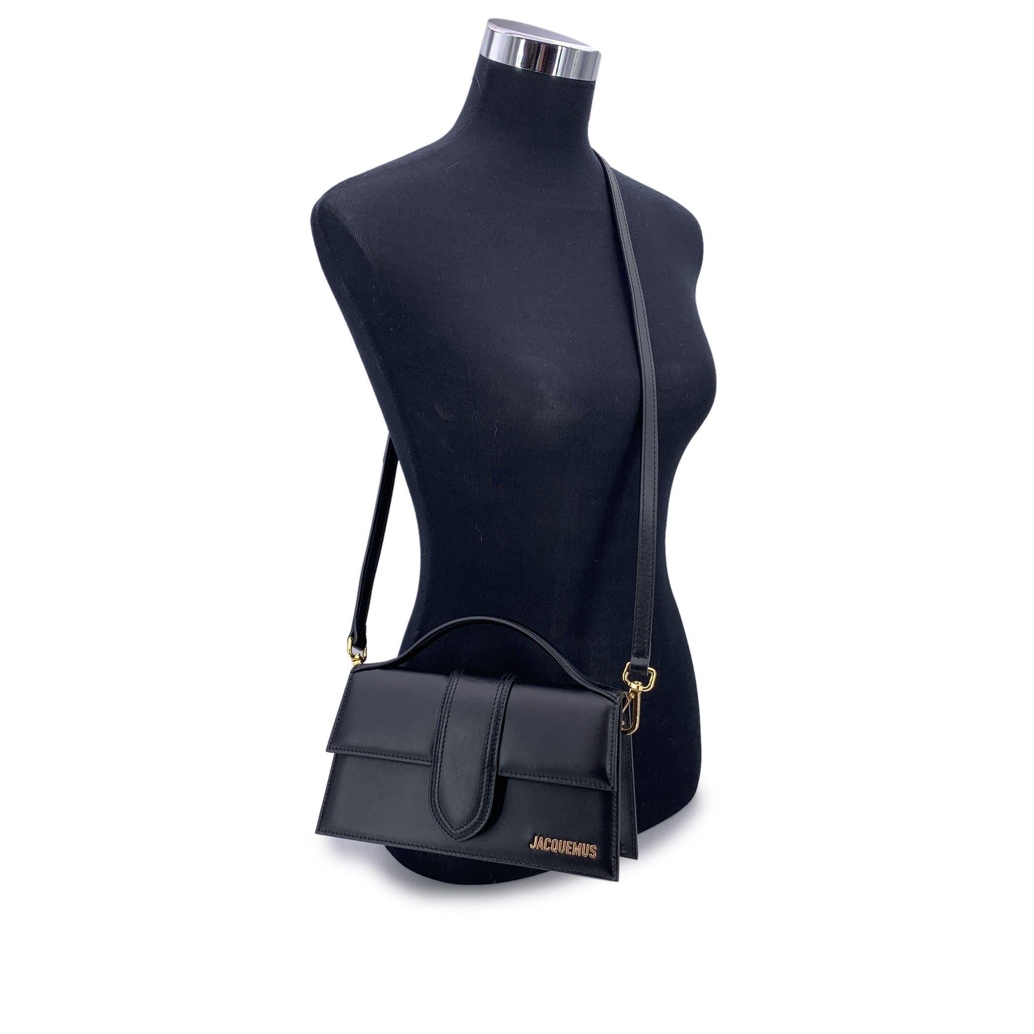 Audace ma raffinato, Le Grand Bambino di Jacquemus è un'icona moderna dal fascino architettonico. Realizzata in elegante pelle nera, questa borsa strutturata cattura la miscela di minimalismo e proporzioni giocose che contraddistingue il marchio