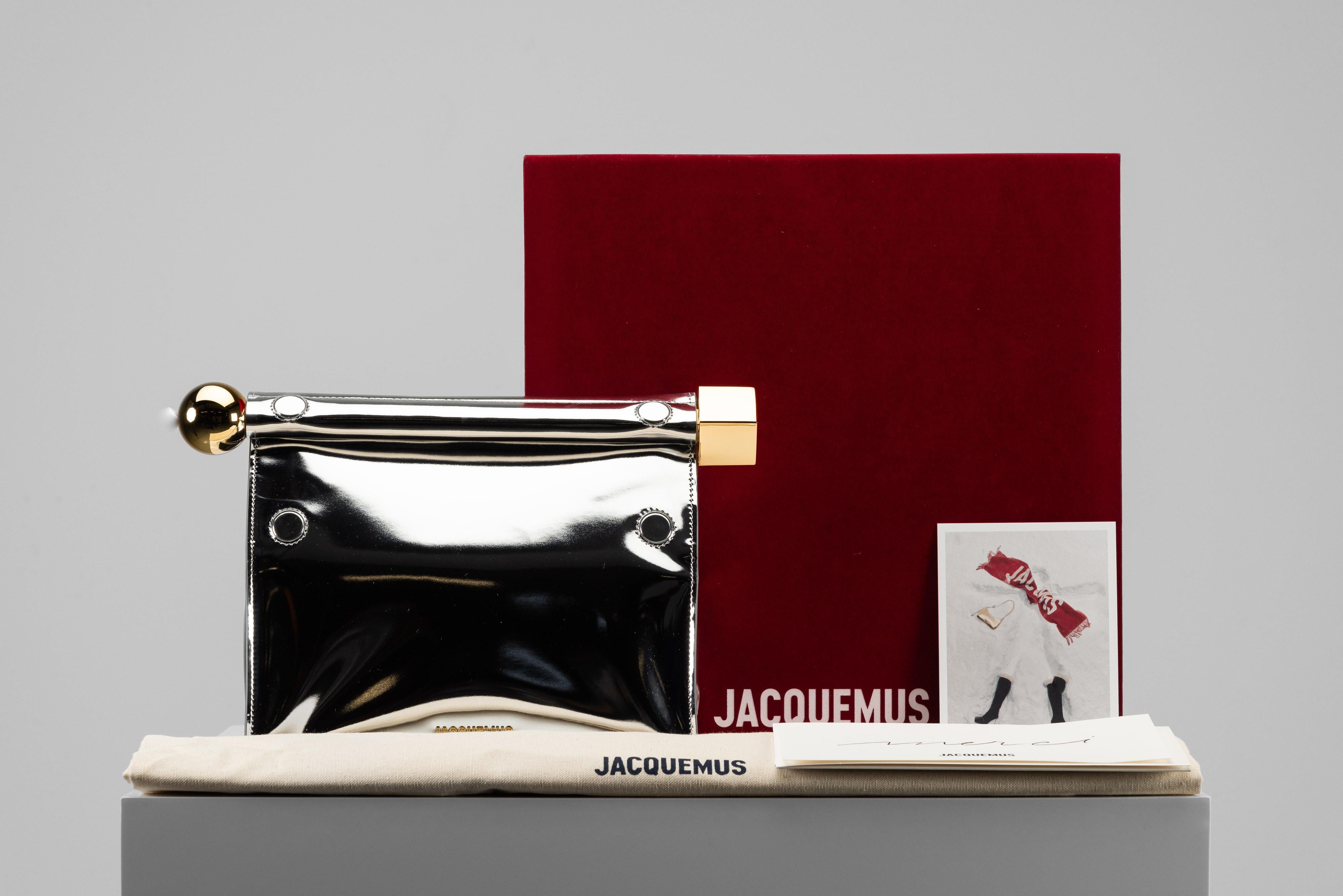 From the collection of SAVINETI we offer this Jacquemus La Pochette Rond Carré NEW:
-    Brand: Jacquemus
-    Model: La Pochette rond carré
-    Color: Silver
-    Year: 2023
-    Condition: NEW (unused)
-    Extras: Full-Set (Dustbag, Box &