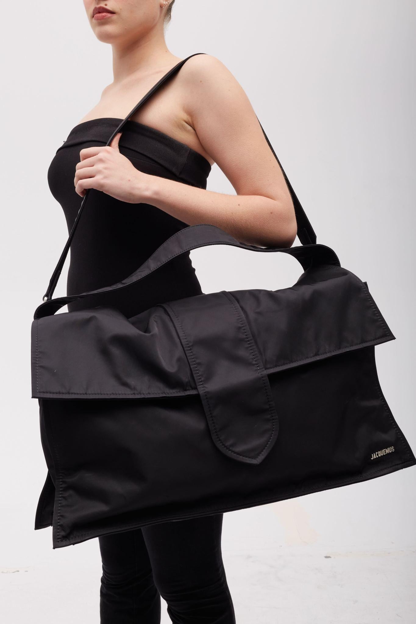 Color: Black
Material: Nylon / synthetic
23H236B313
Comes with: dust bag and retail tag
Condition: This is a sample piece. The bag is in pristine condition. 

Size: Extra large. De Voyage.
Measurements~
Height 12.6”
Width 23.6”
Depth 8”
Shoulder