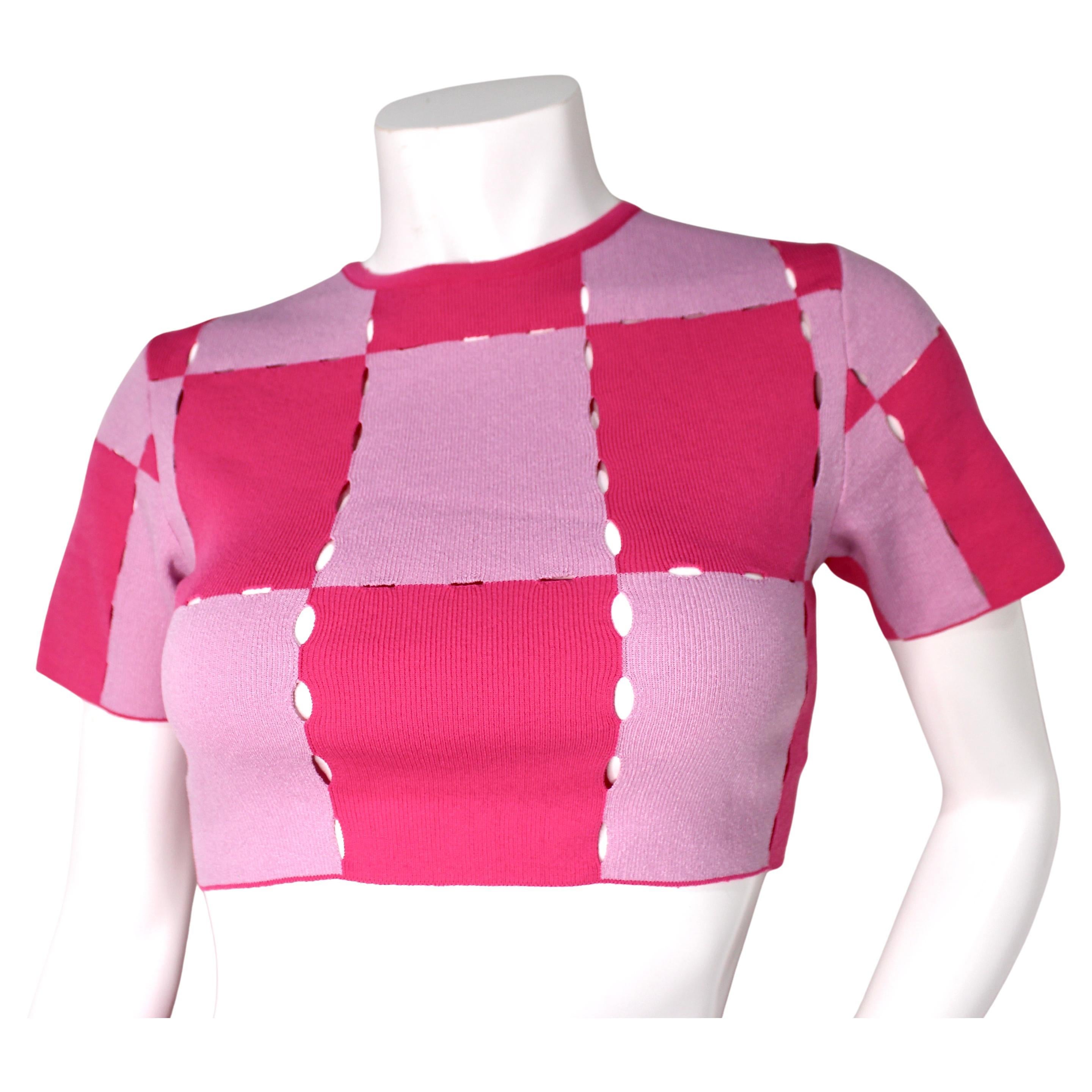 Jacquemus Le Maille Gelato Pink Checkered Knit Crop Top è un capo giocoso e alla moda che incarna la miscela di eleganza moderna e fascino giovanile tipica del marchio. Realizzato in una maglia morbida ed elastica, questo crop top presenta un vivace
