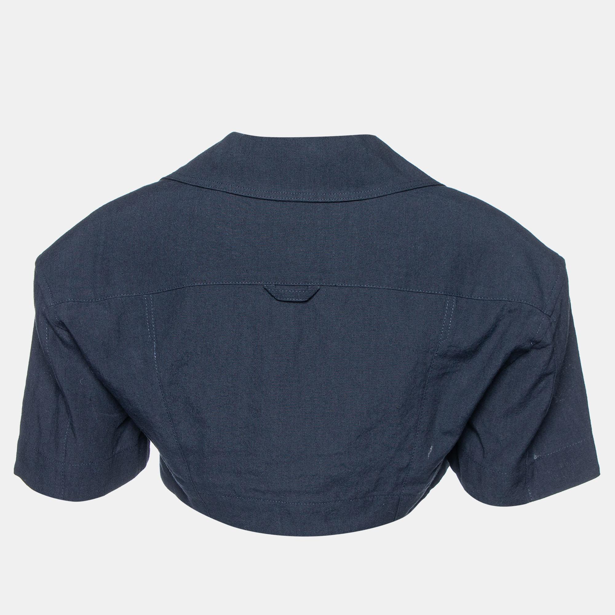 Crafted with a blend of linen and cotton, the Jacquemus Le Haut Bebi Crop Top exudes effortless charm. Its minimalist design features a flattering crop length, perfect for warm days. The rich navy hue adds depth, while the quality fabric ensures
