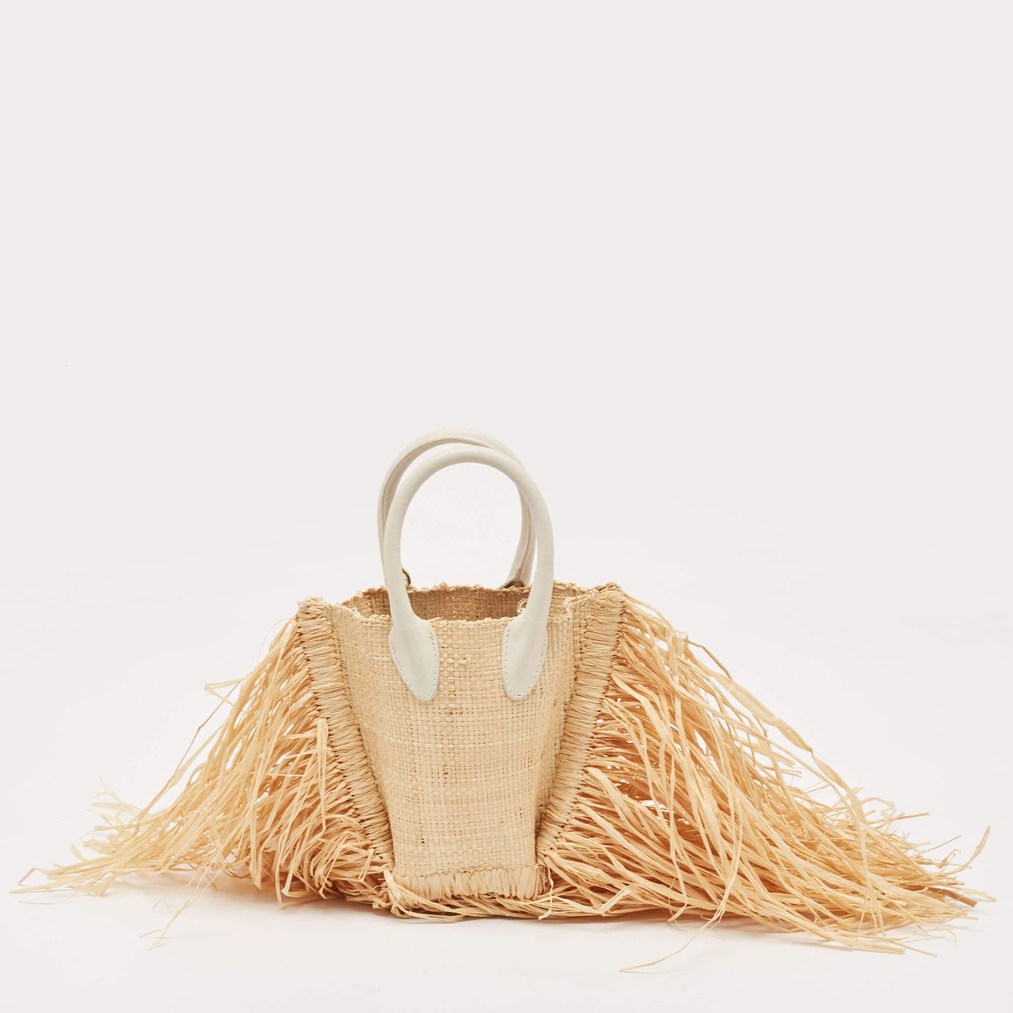 Whether it is a beach or vacation edit, Jacquemus' Let Petite Baci bag promises effortless style. Made of straw and leather, the bag has exaggerated fringes, two shapely handles, and the logo on the front.

Includes: Detachable Strap