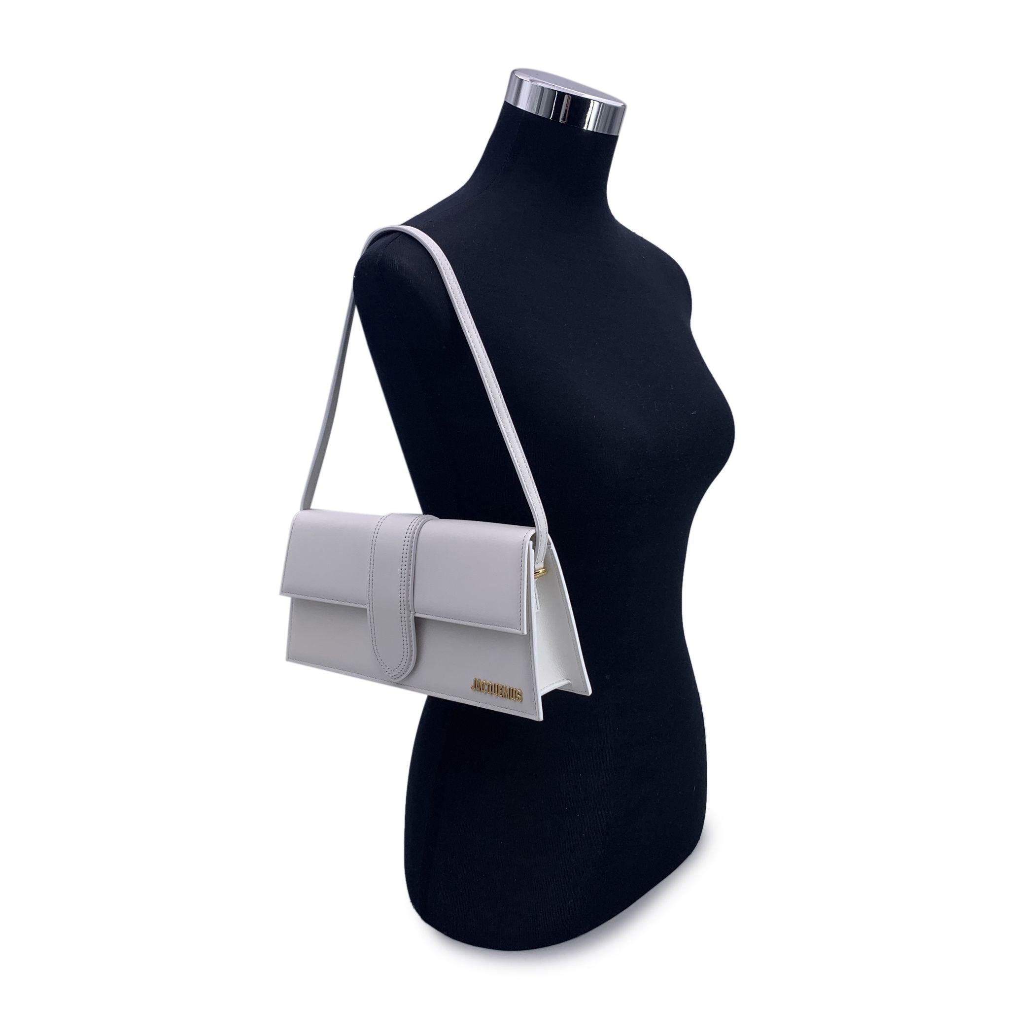 Jacquemus white leather Le Long Bambino Structured box bag. Gold metal logo on the front. Thin non-adjustable shoulder strap. Flap with magnetic button closure. 1 open pocket on the back. Beige canvas lining. 1 side open pocket inside. 'Jacquemus -