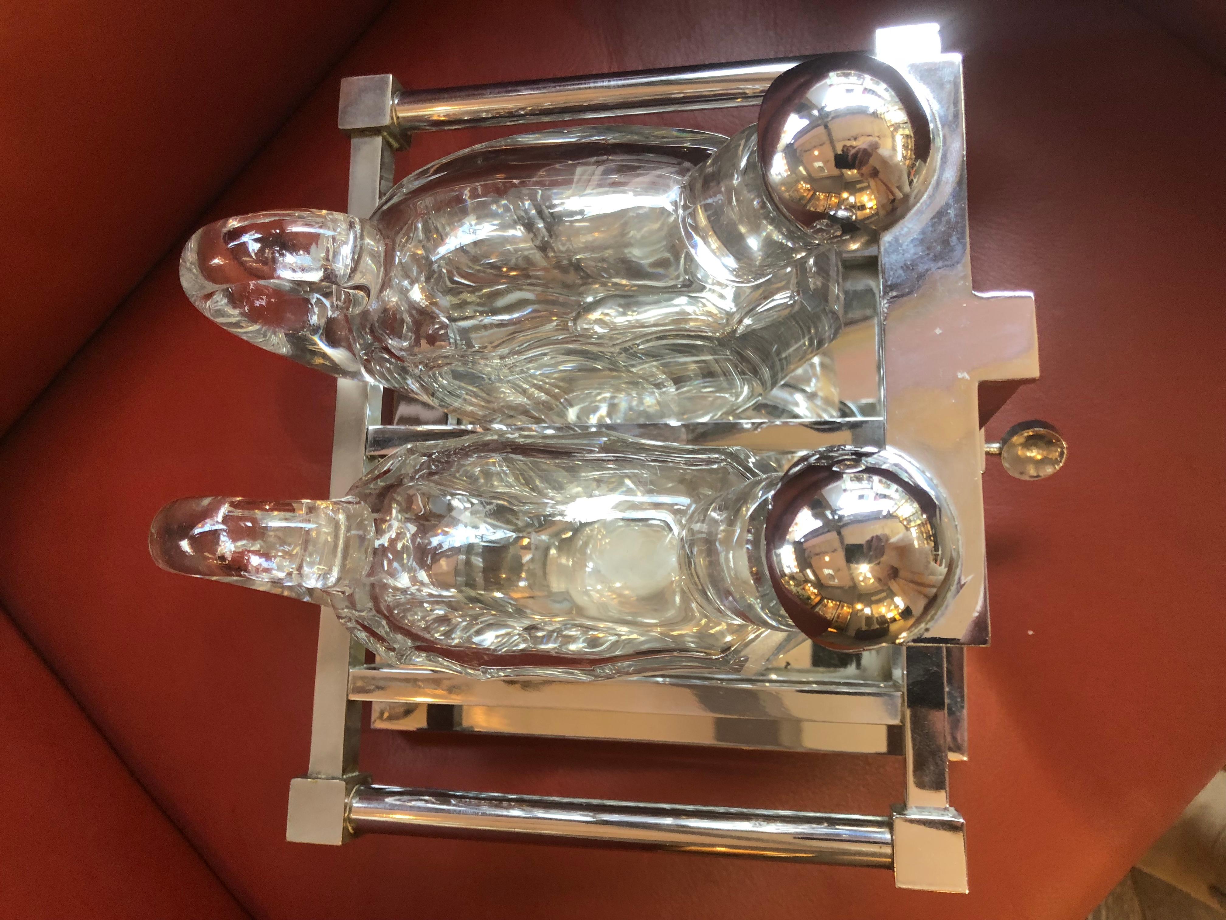 Liqueur cellar in chrome bronze with double rectangular trays decorated and presenting 2 flasks in Baccarat flat rumen crystal.
Cellar liqueur Jacques Adnet, modernist (1900-1984).
Geometric structure in chromed metal with 2 Baccarat crystal