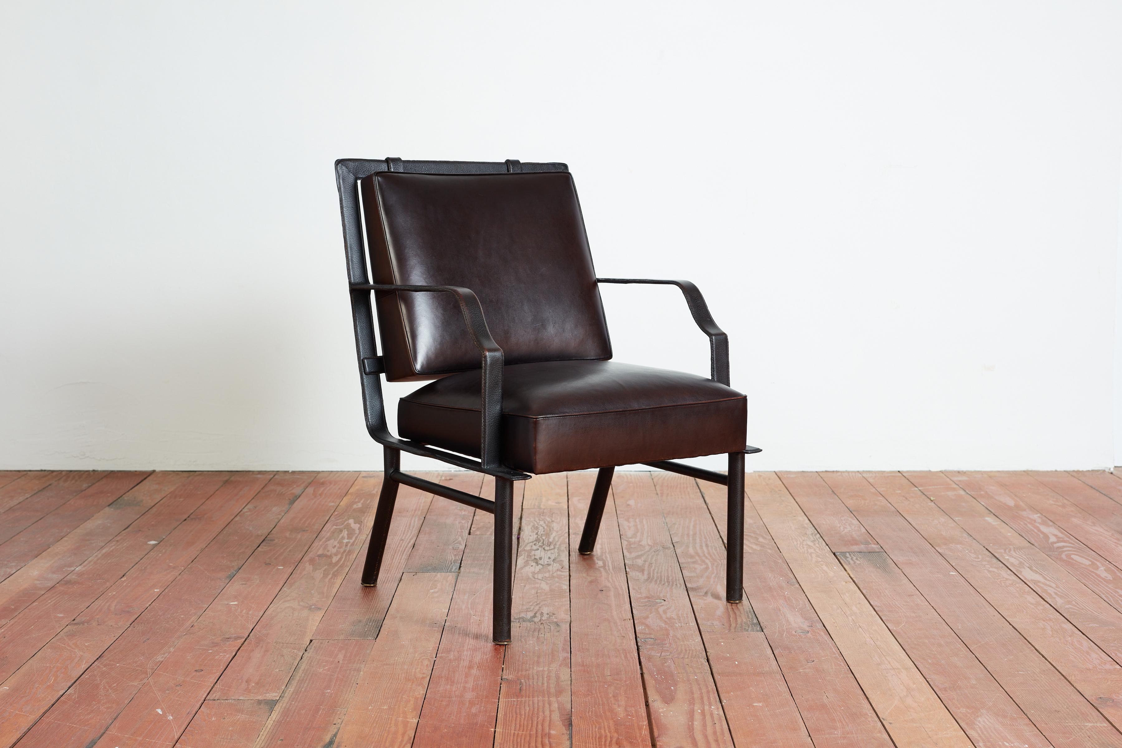 Rare Jacques Adnet Arm Chair 
Signature saddle stitched leather over heavy steel with deep chocolate seat and back
Floating back cushion is attached with unique saddle stitched clips
Wonderful design.
France, c. 1955

