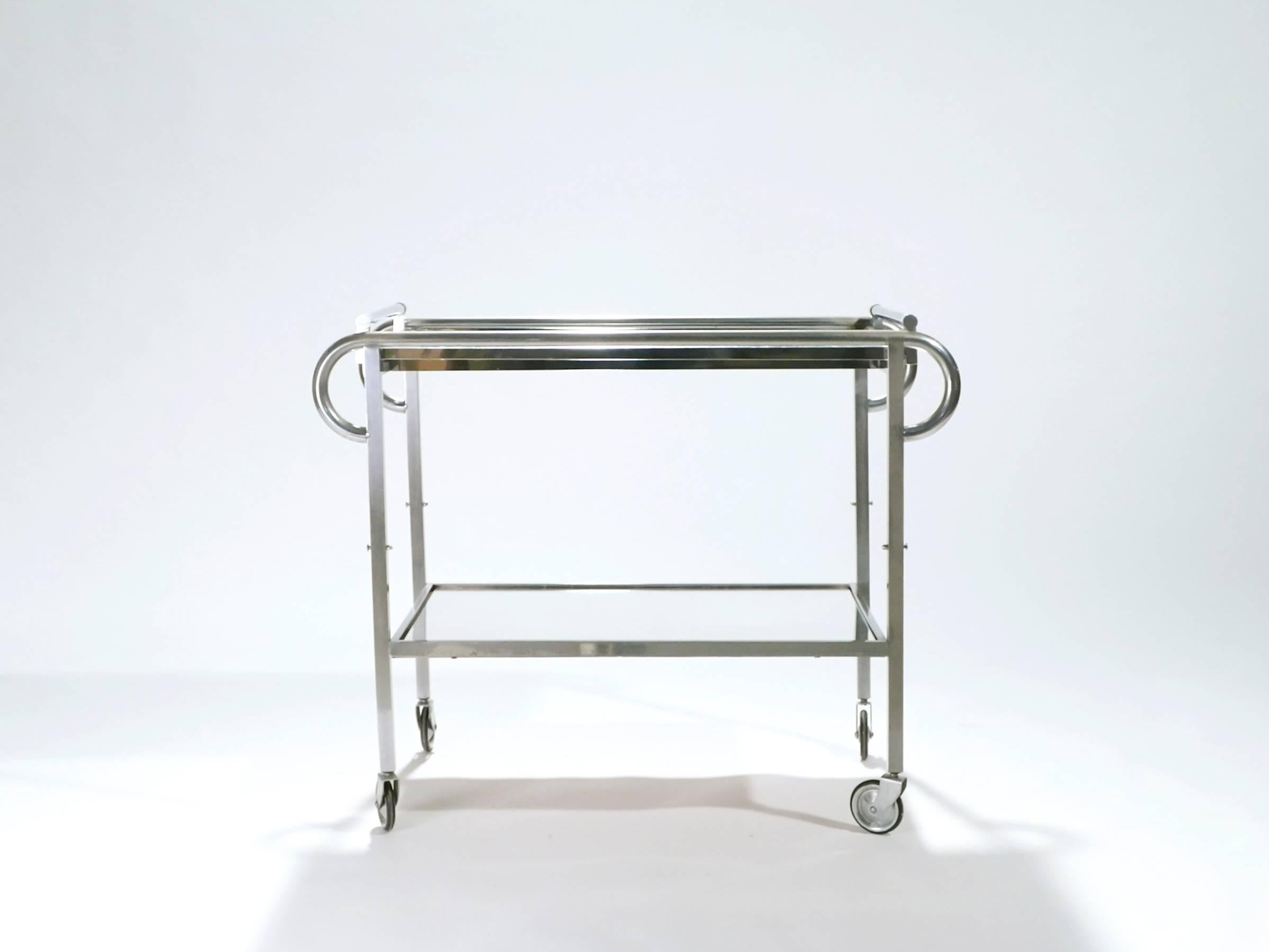 This chic bar cart from the 1930s carries with it the elegant mood of the late Art Deco period, especially with its bold, modern use of high-quality metals. It’s set on functioning wheels and has 2/3 mirrored surfaces on which to store your bottles