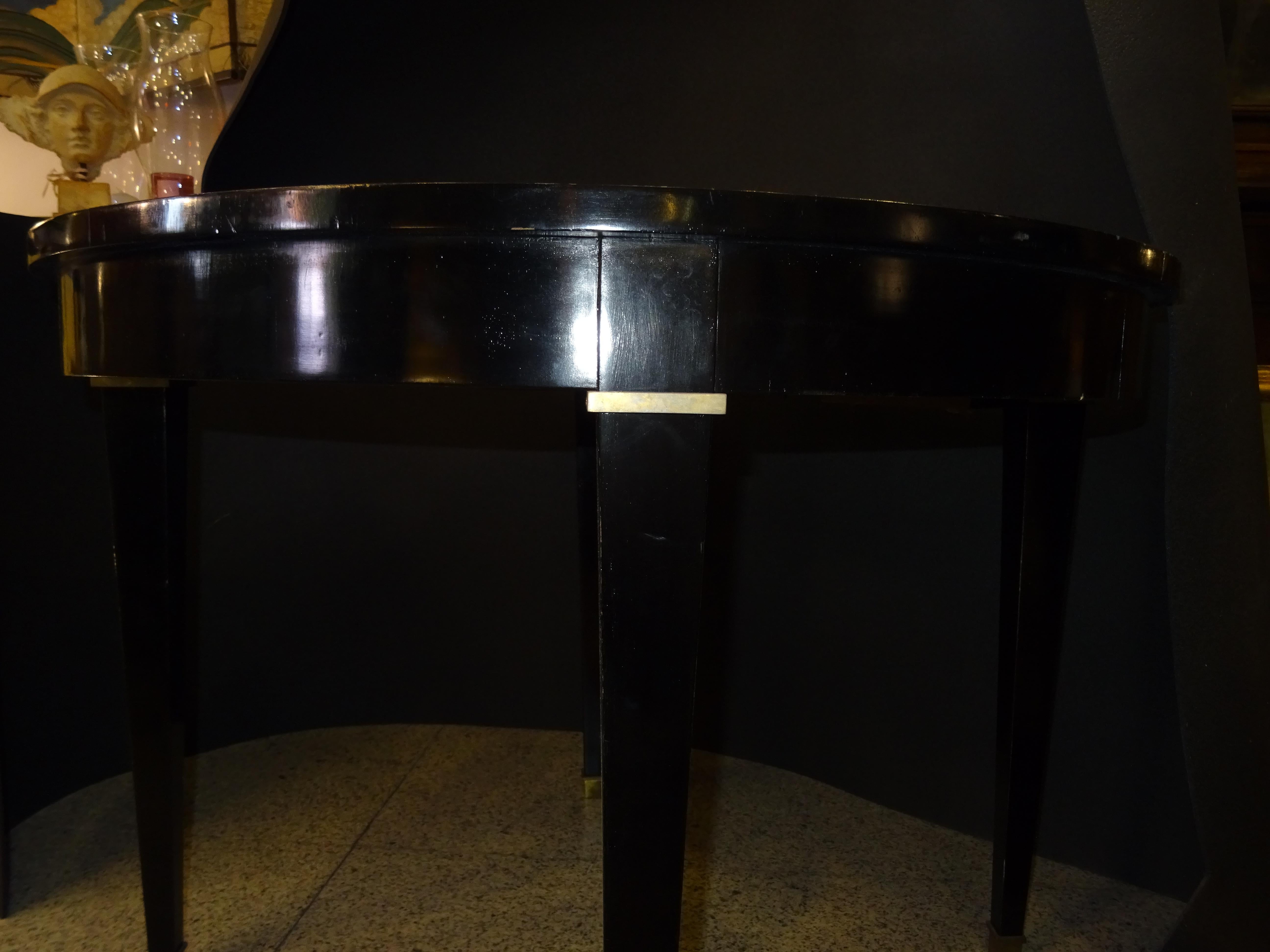 Outstanding and very refined round table by Jacques Adnet (1900-1984) one of the best architects and interior designers in the first half of the 20th century.
This table is in French black lacquered wood with a beautiful line of brass inlaid around