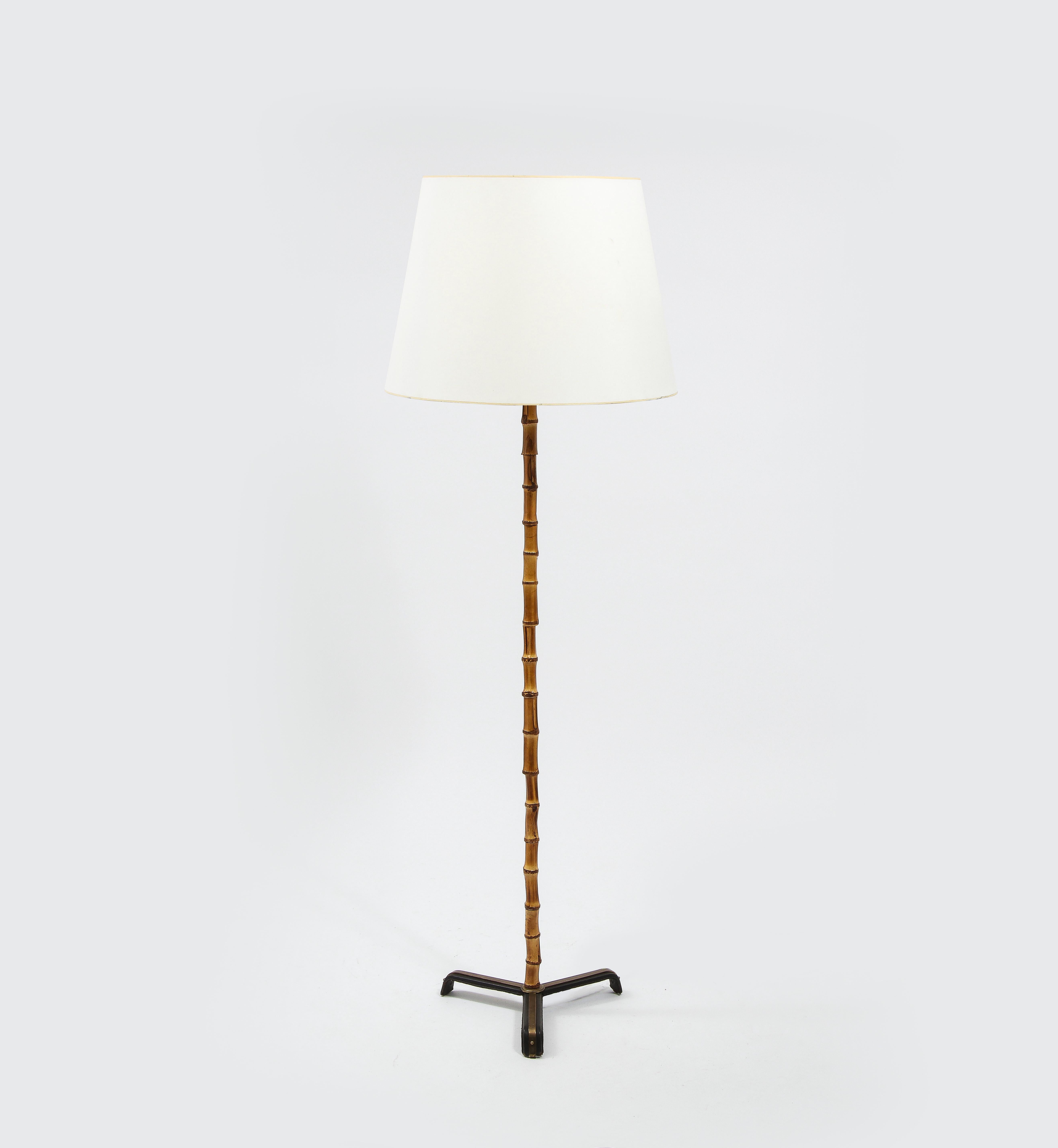 Important Jacques Adnet bamboo floor lamp, the base is in leather stitched over wrought iron with elegant brass details, the stem in natural root bamboo with very nice details, we kept the original socket. Rewired.