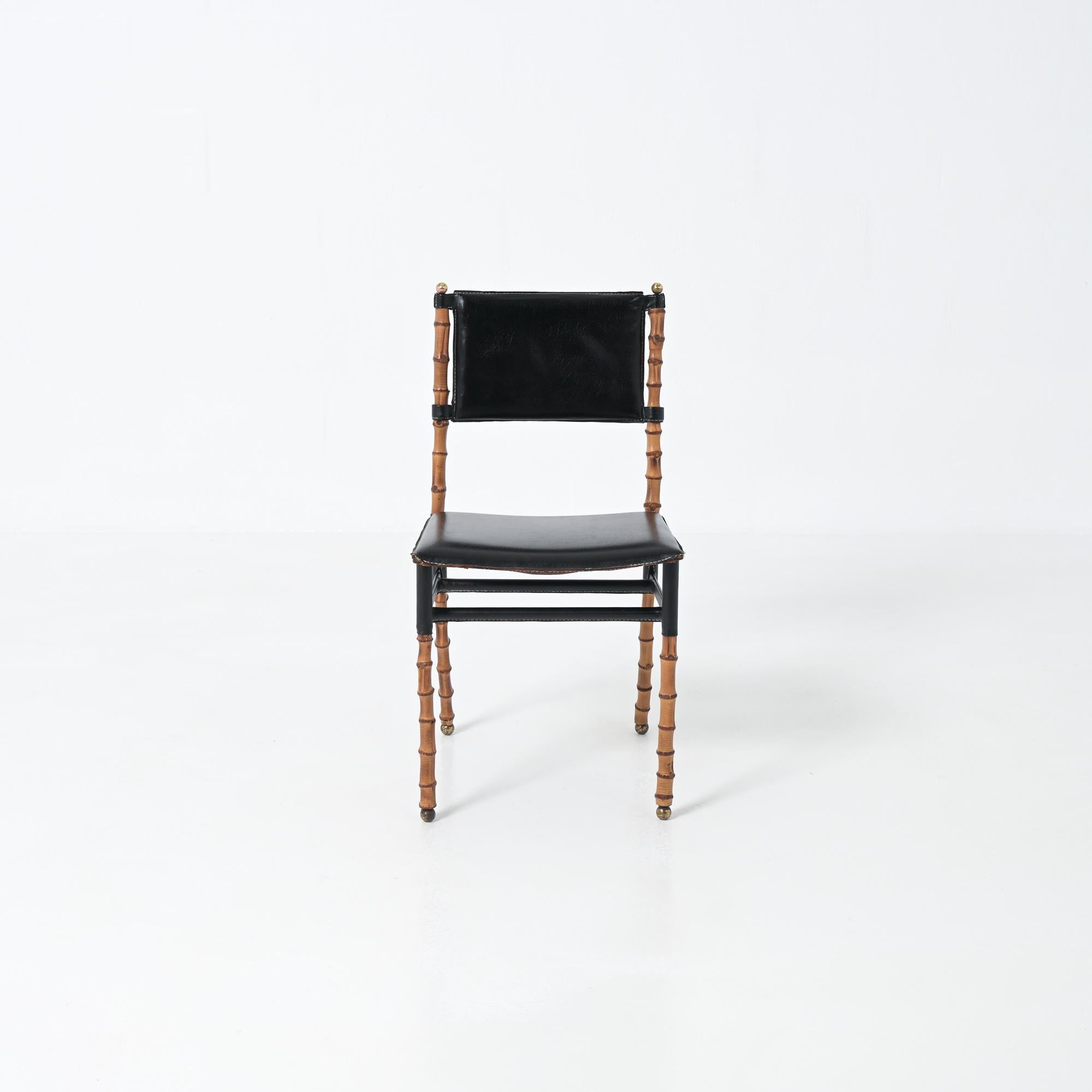 This very rare chair was designed by Jacques Adnet. The chair has a metal frame over which the bamboo poles are slid. The bamboo only has a decorative function. The leatherette of the seat has worn through at the corners. The filling of the seat is