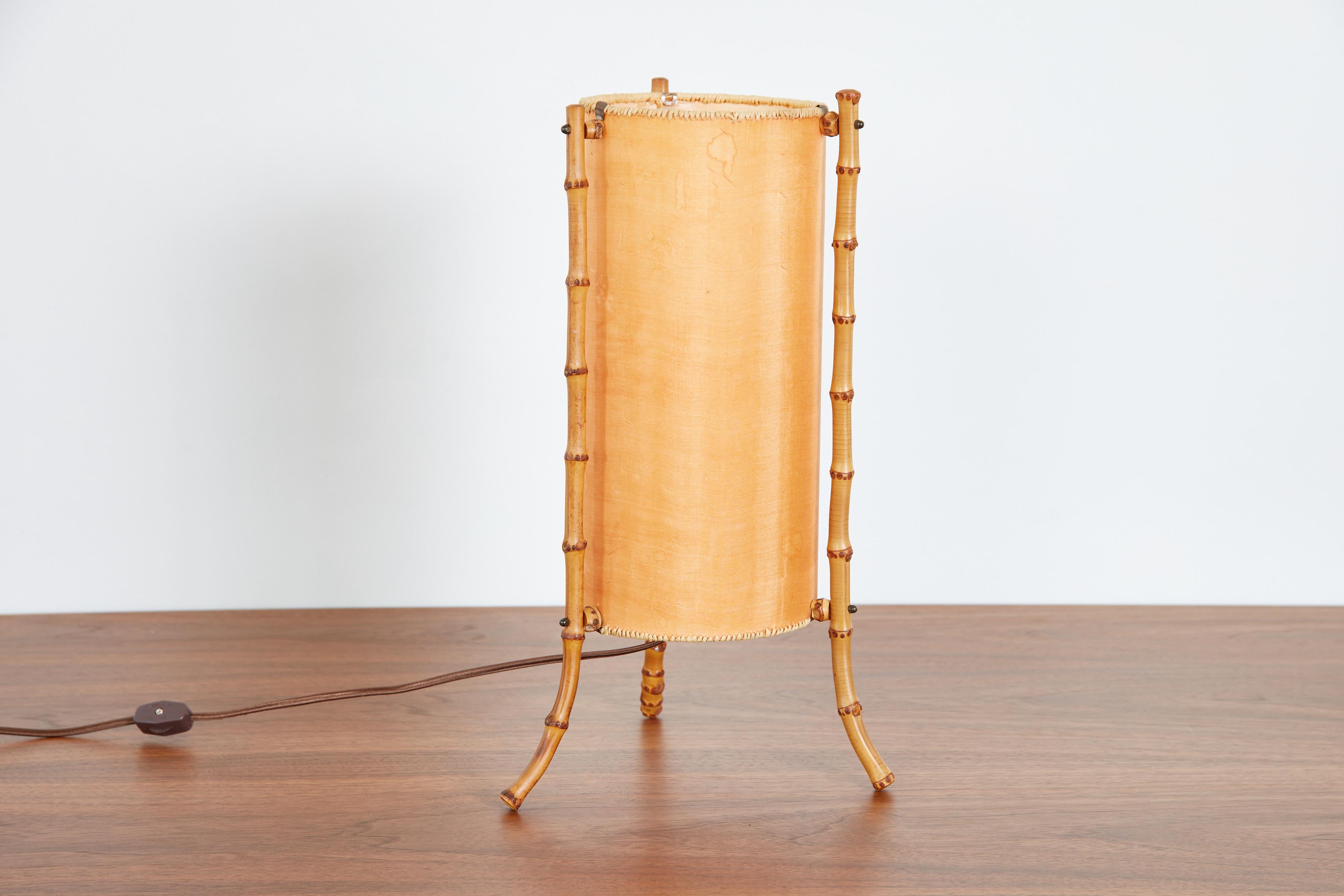 Gorgeous table lamp by Jacques Adnet 
Original shade with whipstitching and bamboo frame 
Beautiful patina
Newly rewired