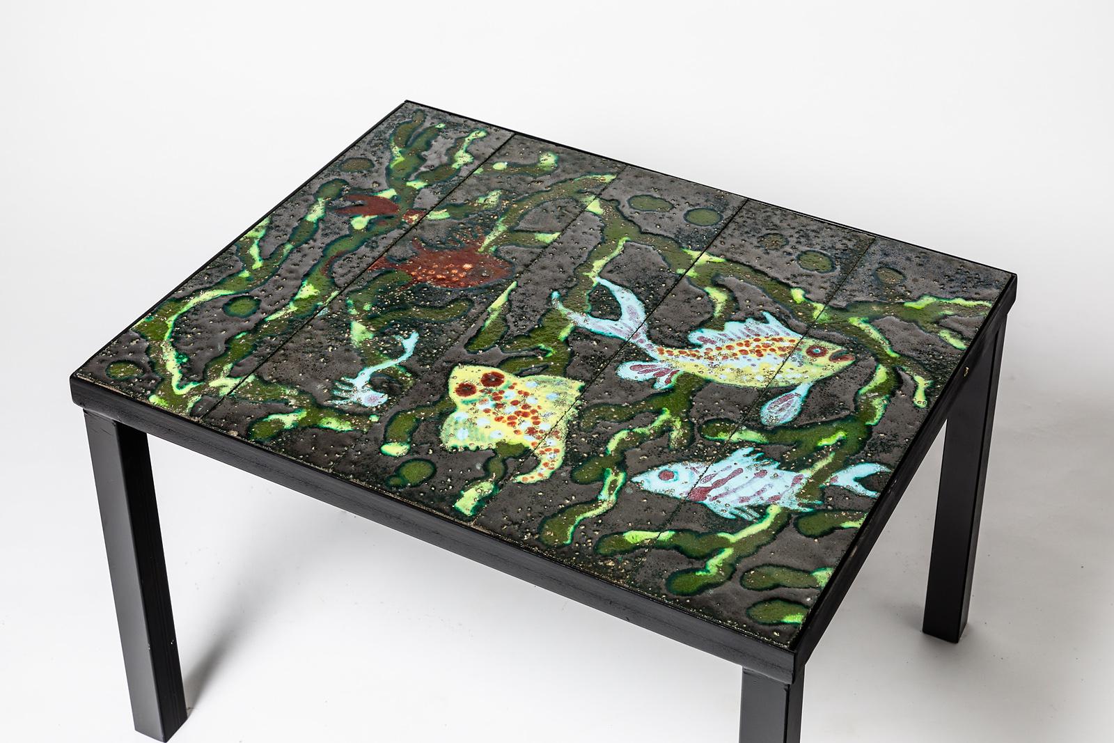 Jacques Adnet

Elegant and decorative black low coffee table.

Original colored fishes decoration. French 1930 decorative art.

Original perfect conditions

Measures: Height 40cm, longer 65cm, large 50cm.