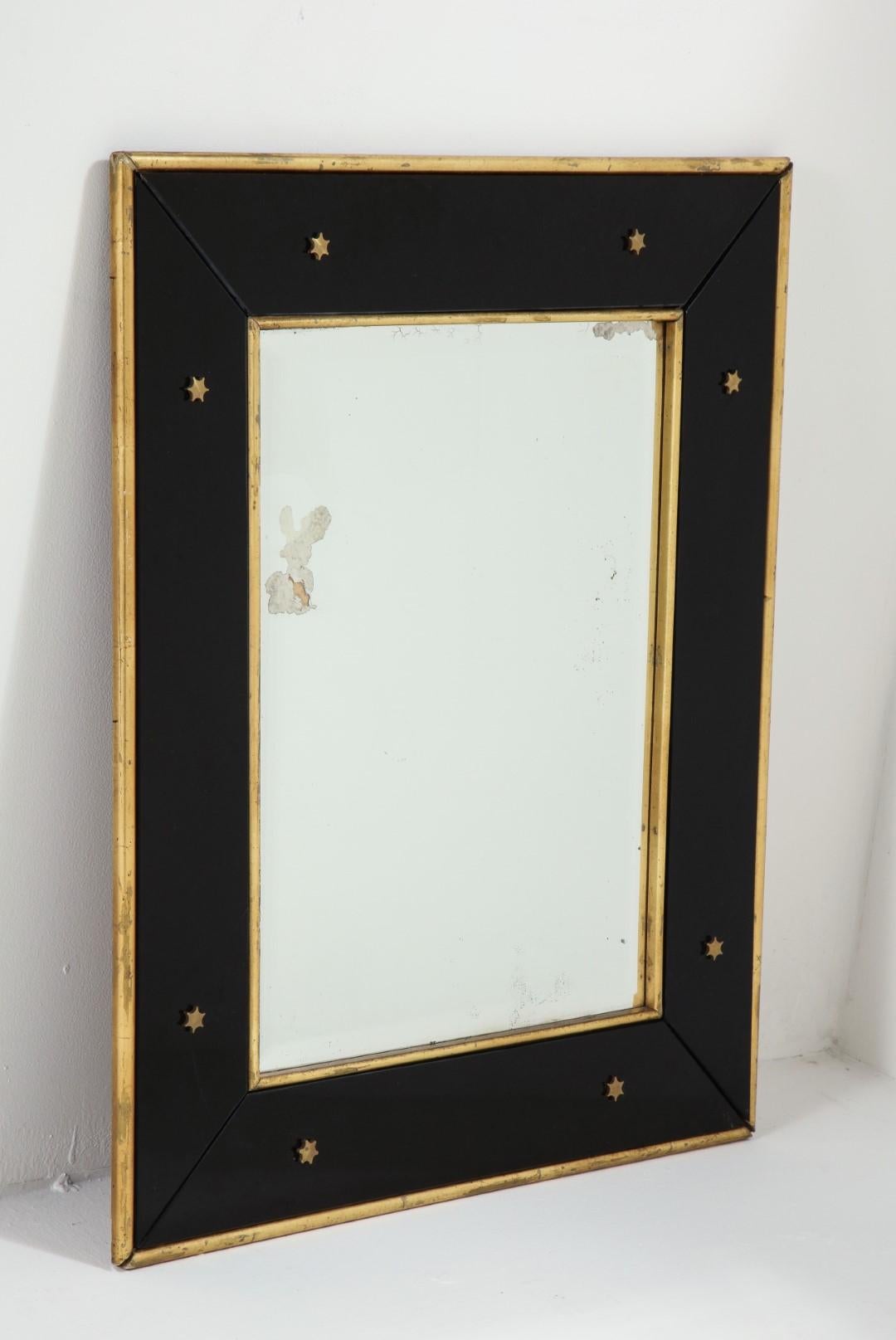 Wall mirror by Jacques Adnet, circa 1940. Black glass frame with gold leaf border and star detail on the glass.