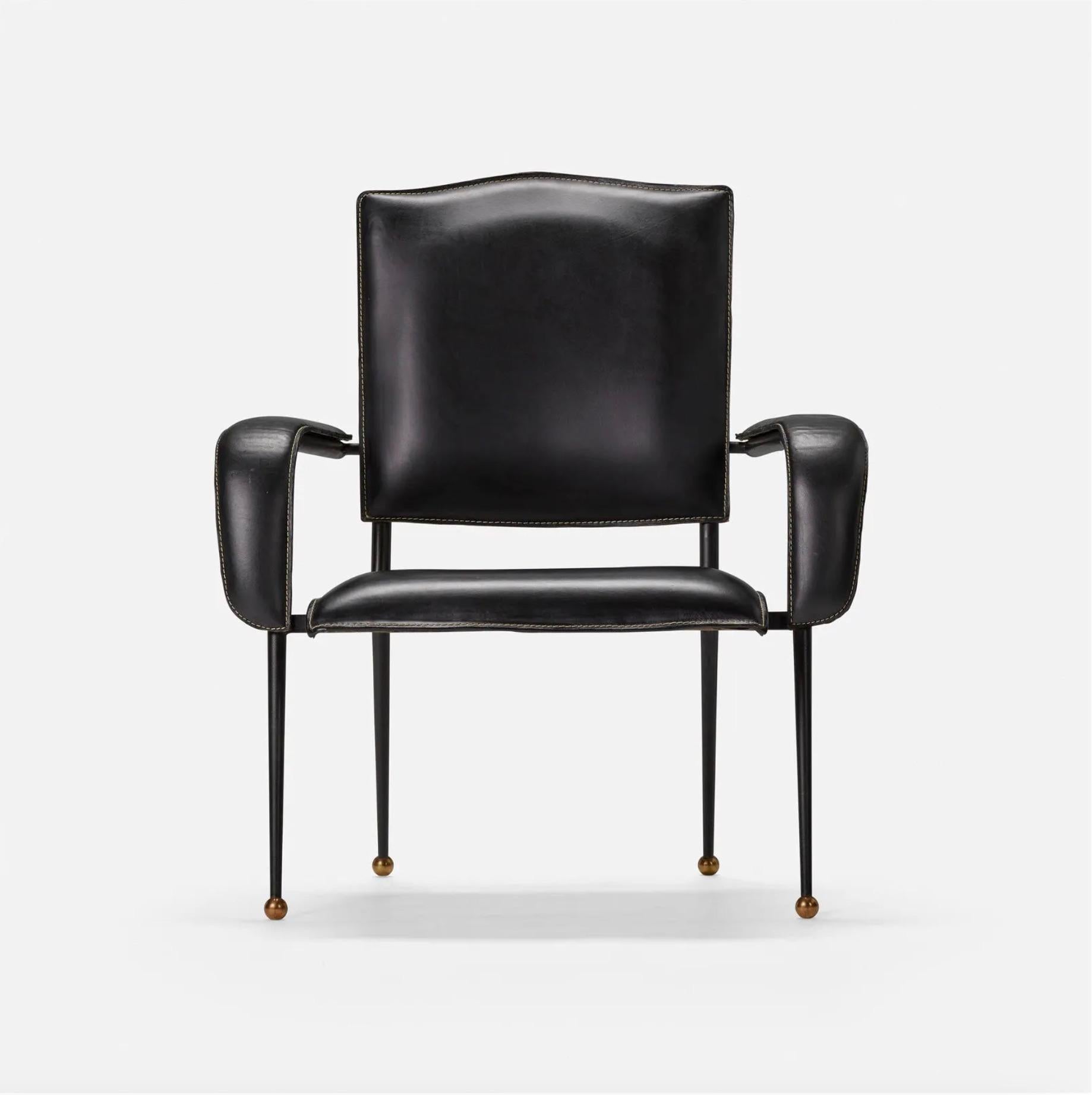Stunning leather armchair by French designer Jacques Adnet. Black iron frame sitting atop brass ball feet. Black leather seat, seat back and arm rests with signature Adnet contrast stitch at the seams. Good original condition. Extremely comfortable.