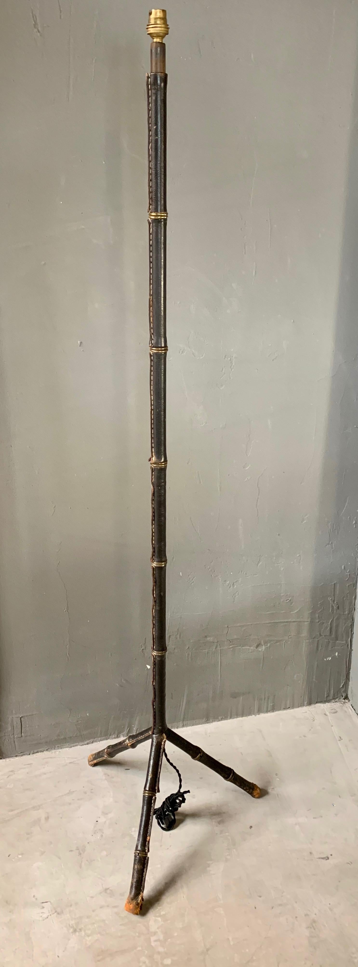 Classic leather floor lamp by French designer Jacques Adnet. Beautiful patina to black leather with signature Adnet contrast stitching. Entire lamp is wrapped in leather. Newly wired. New linen shade. Original condition. 

Floor lamp dimensions