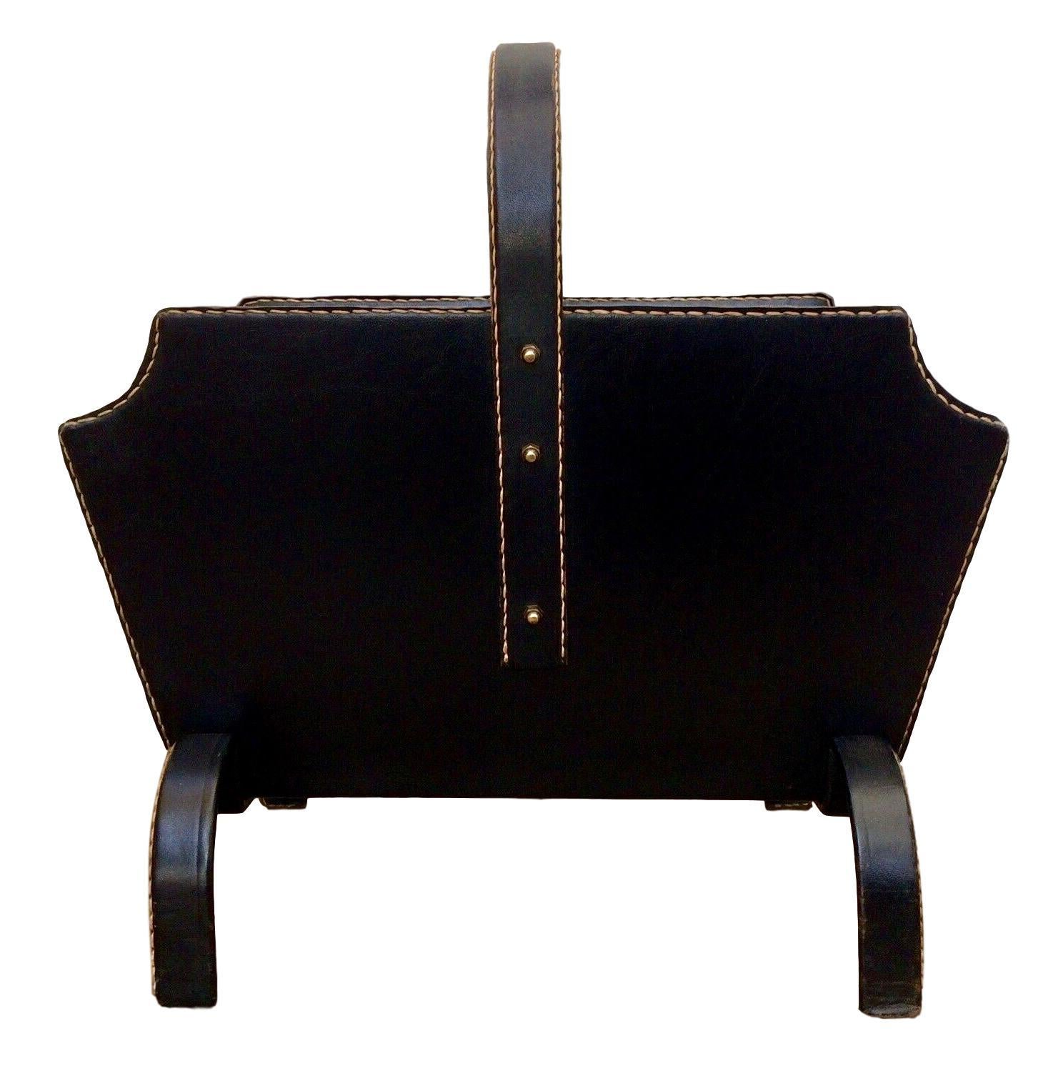 Stunning black leather magazine rack by Jacques Adnet. Signature Adnet contrast stitching with brass hardware. Very good original condition. Completely wrapped in leather.


    
   