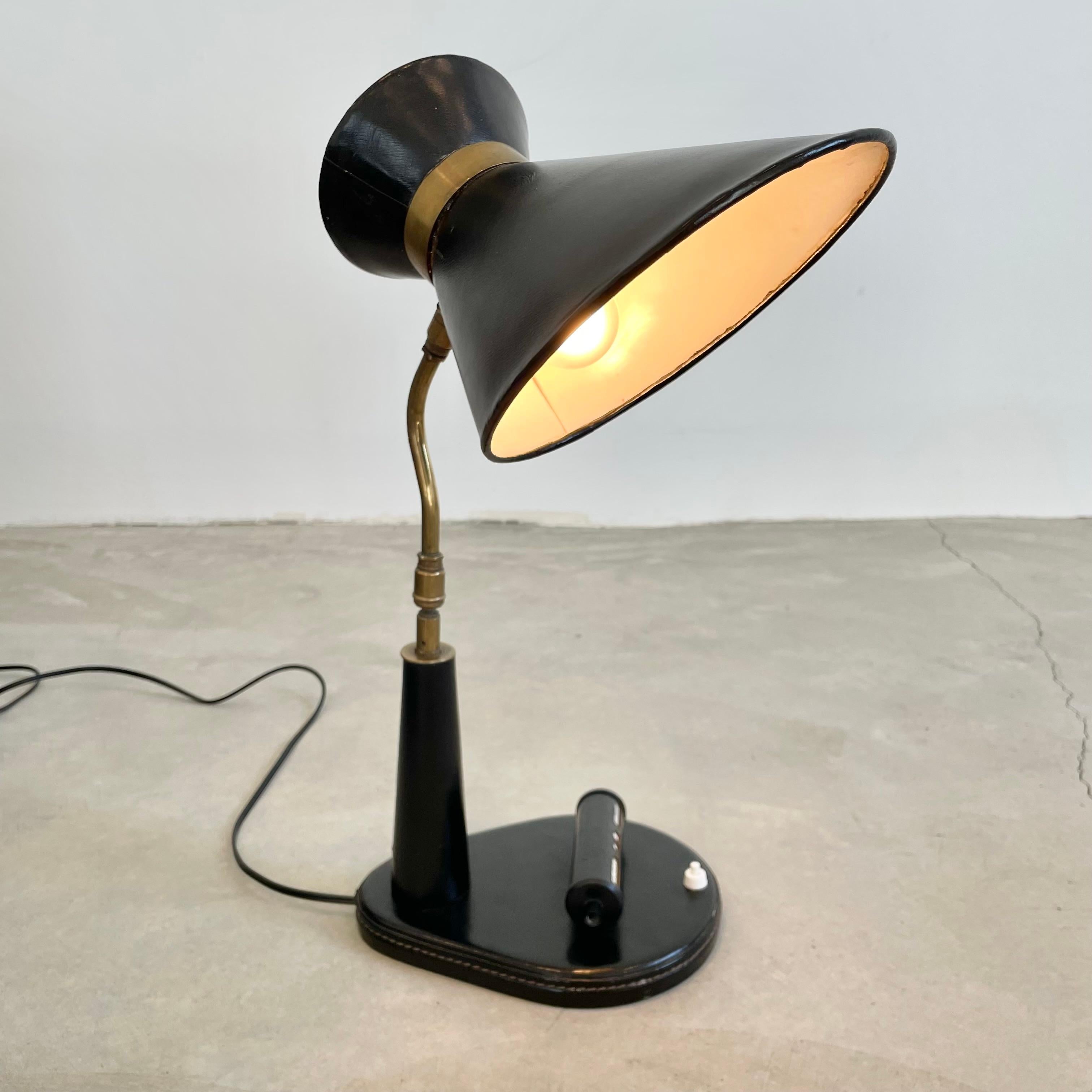 Elegant Jacques Adnet leather table lamp with adjustable date display on the base. Neck is attached at the base and at the top with a brass ball joint which gives it an array of positions you can adjust it to. The frame is completely wrapped in a