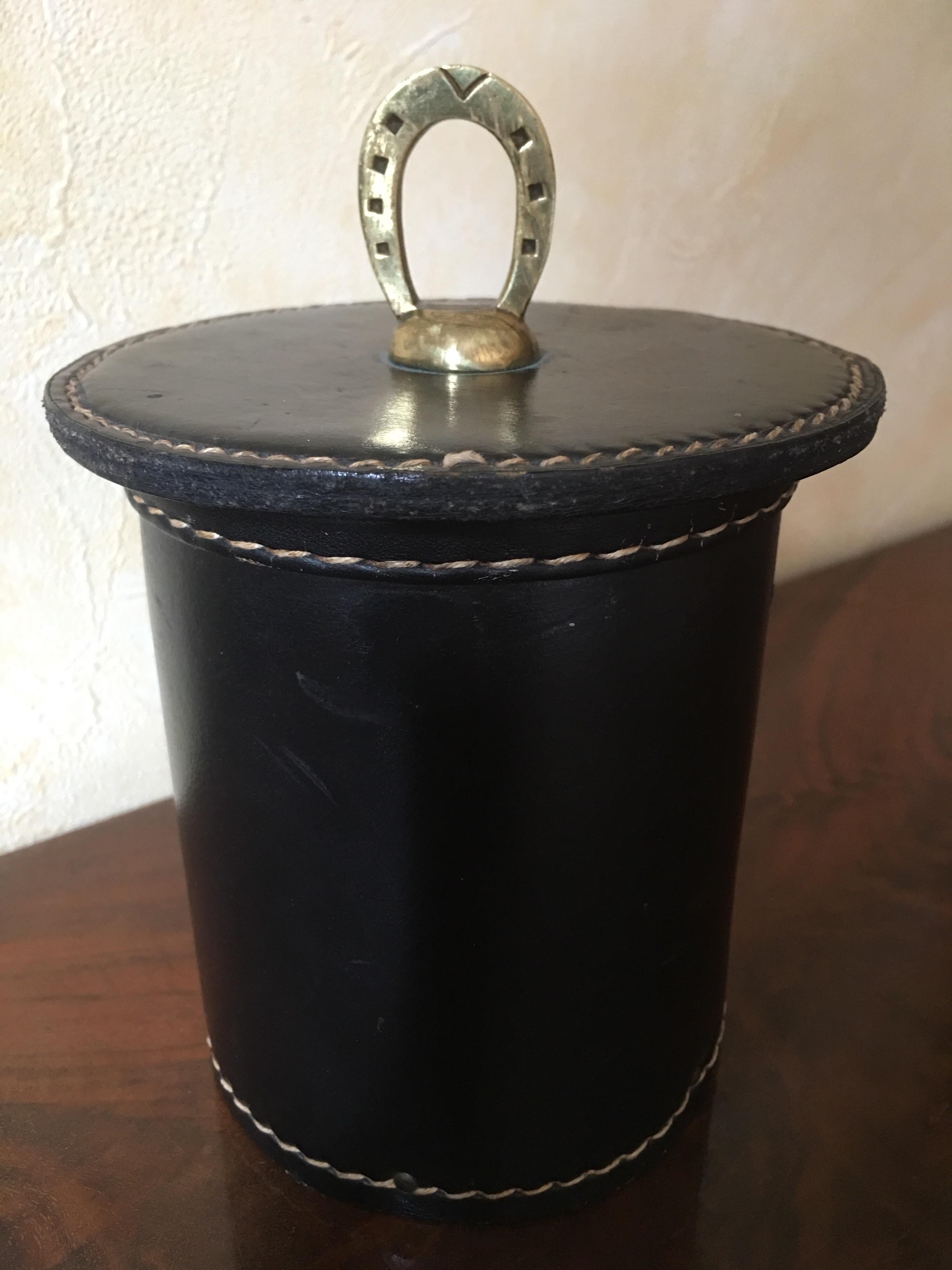 Rare black stitched leather box designed by Jacques Adnet in France in 1950s.
Original leather with very minor wear, bronze gripping ring in the shape of a horseshoe. In very good condition.
A copy of an original photo in 1950s with a similar box