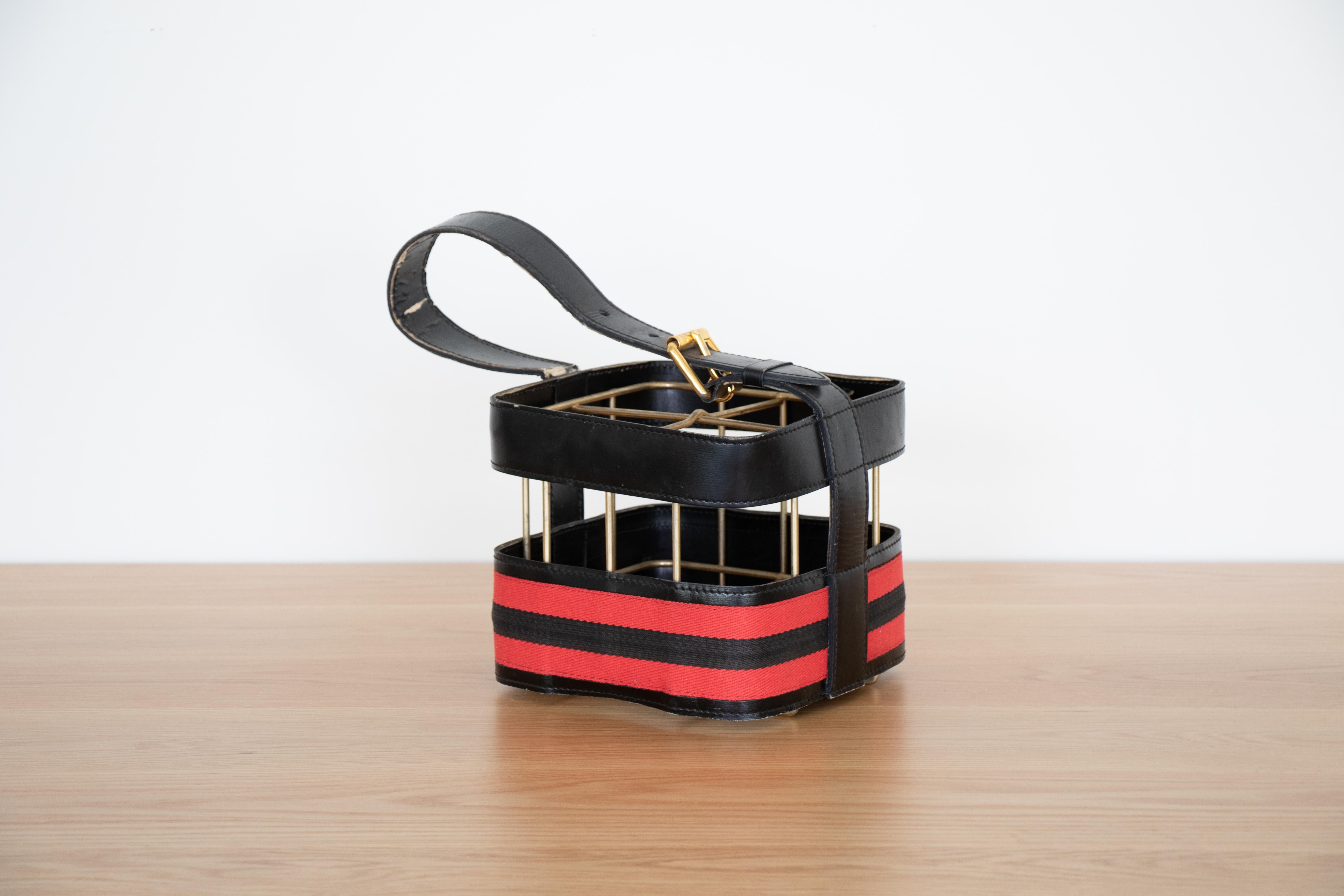 French 1940s leather and brass 4 bottle holder by Jacques Adnet. Black leather with red and black cotton stripe around side. Nice original vintage condition.