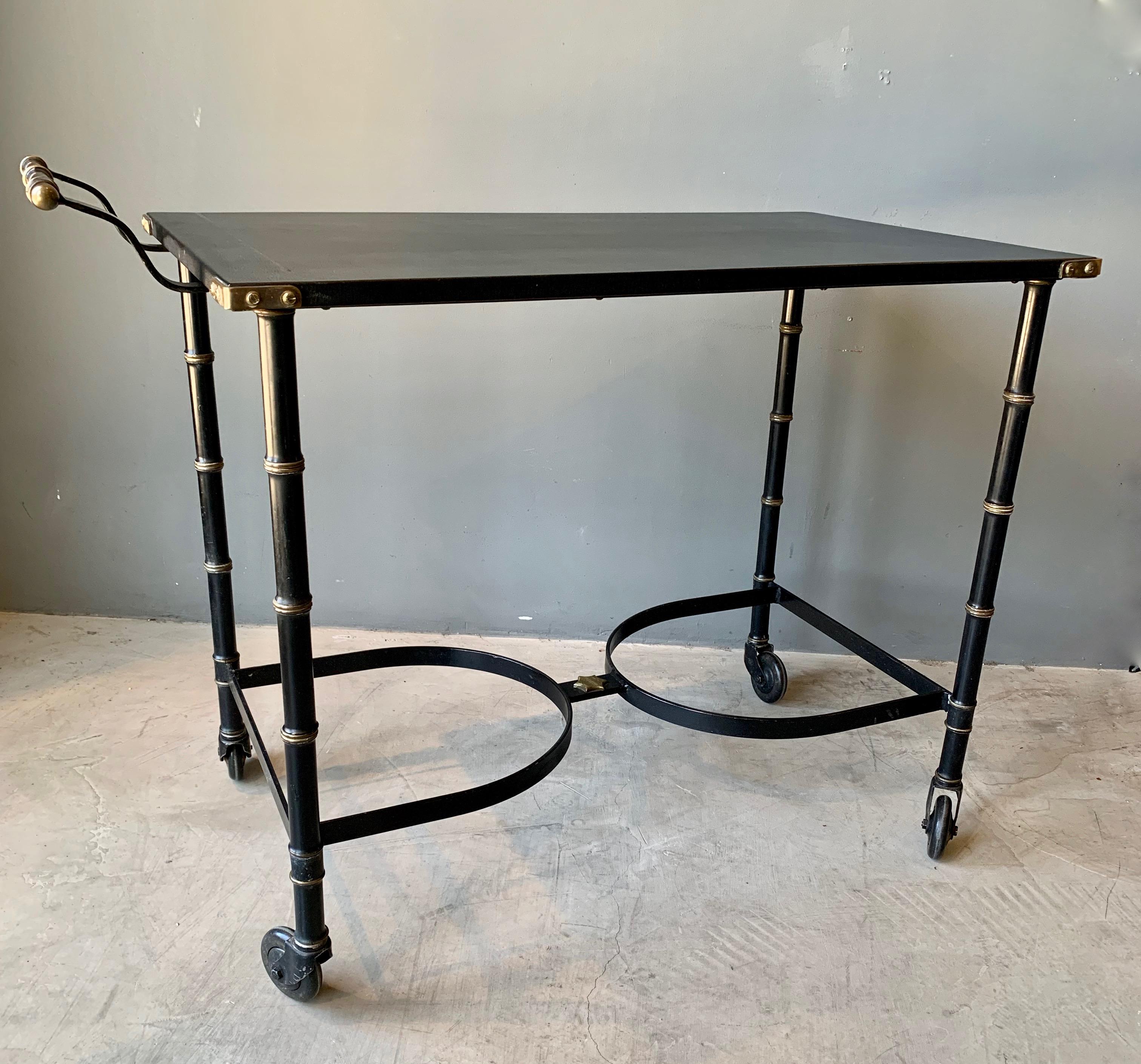 Classic serving cart by Jacques Adnet. Very good original condition. Iron bamboo frame with brass detailing. Leather top with brass corners and brass star on base. Great piece of collectible Adnet.

 
 