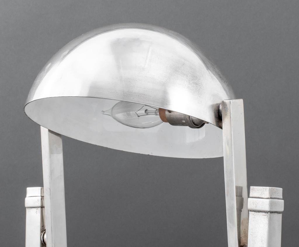 Jacques Adnet (French, 1900-1984) chromed table lamp, circa 1930, the hemispherical shade adjustable on swinging cantilevered frame flanked by two supports on stepped stained oak base, on chromed plinth.  18.75