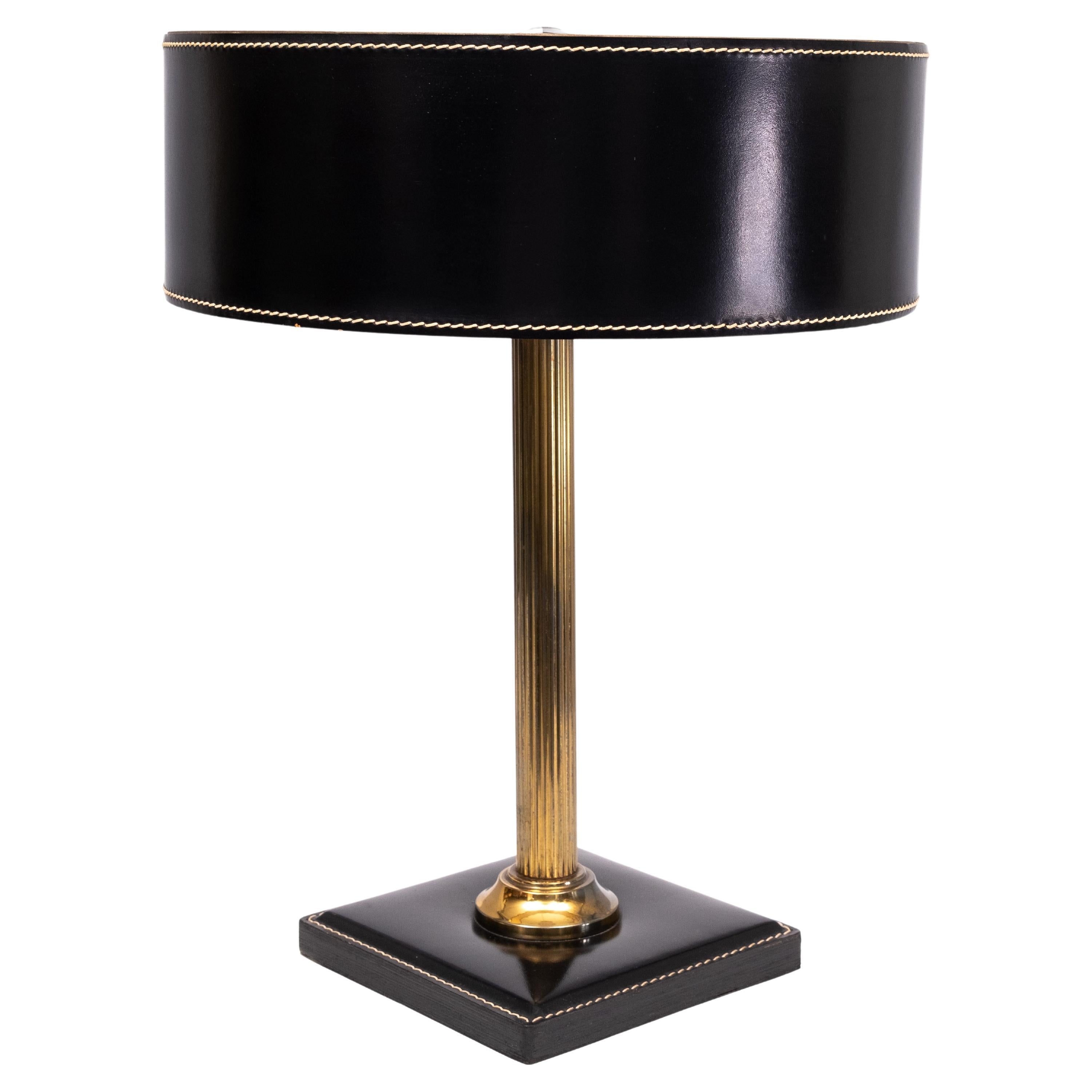 Très belle lampe de table en cuir noir. Colonne en laiton .
Design/One par Jacques  Adnet en  les années 1960 .
Très bon état, lampe de table élégante et stylée.  