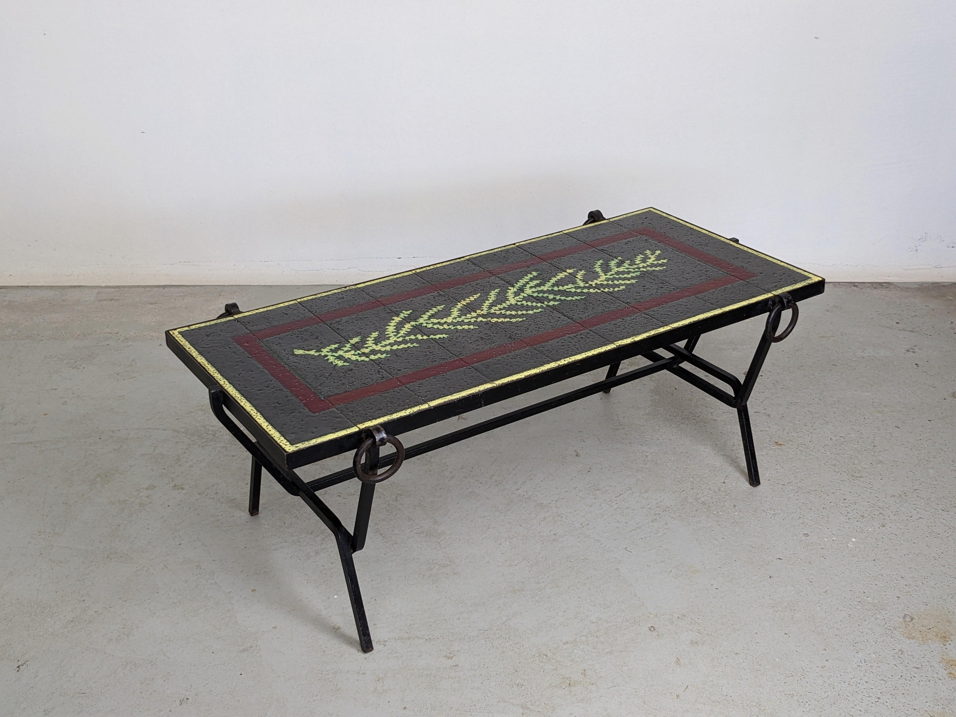 Mid-Century Modern coffee table by renowned french designer Jacques Adnet.
Black lacquered metal structure with a glazed stoneware top.

Beautiful table top made of 9 glazed tiles representing a stylised leaf. 
Each tiles are numbered.

