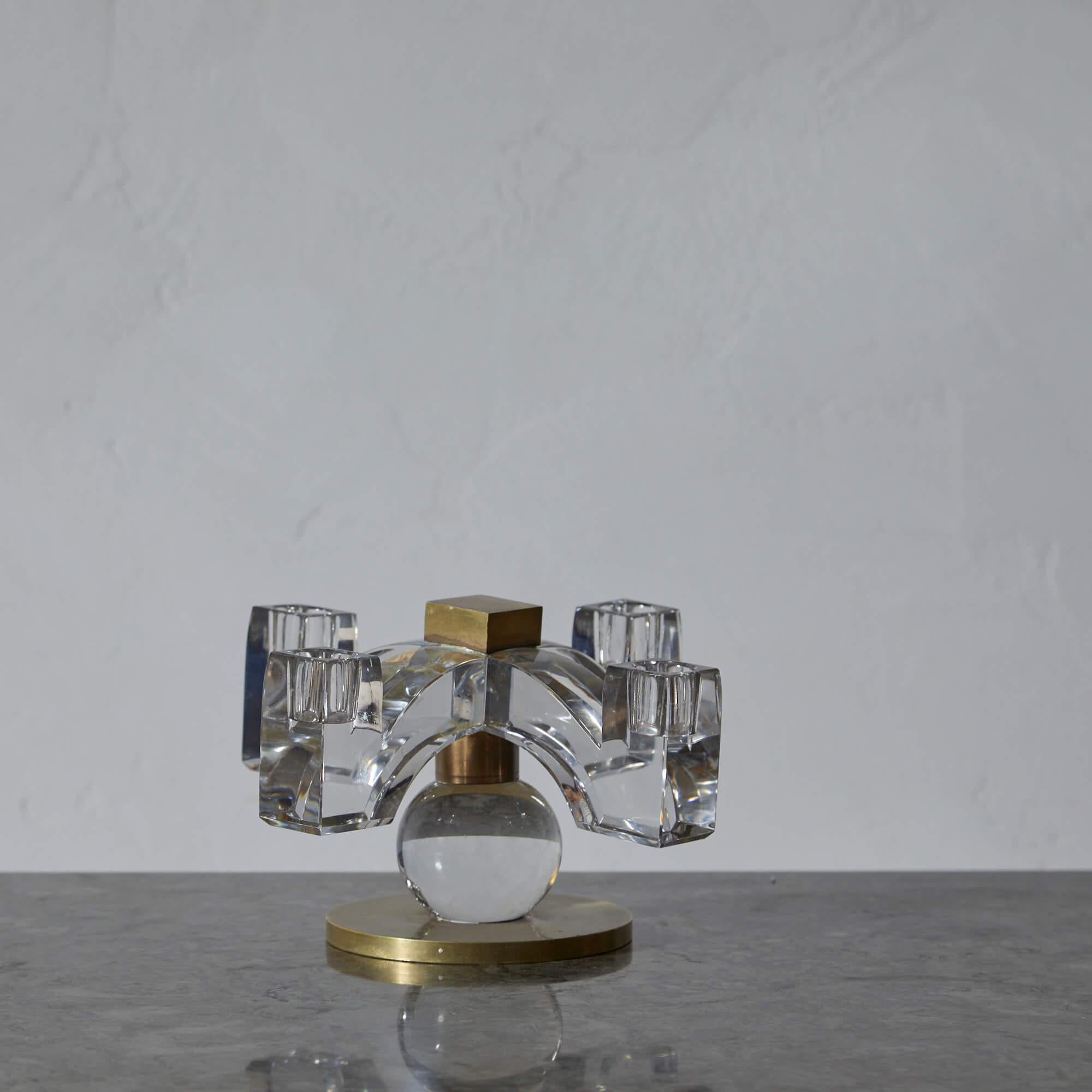 Candelabro a quattro luci in cristallo e bronzo disegnato da Jacques Adnet per Baccarat. La superficie metallica presenta una patina calda.

