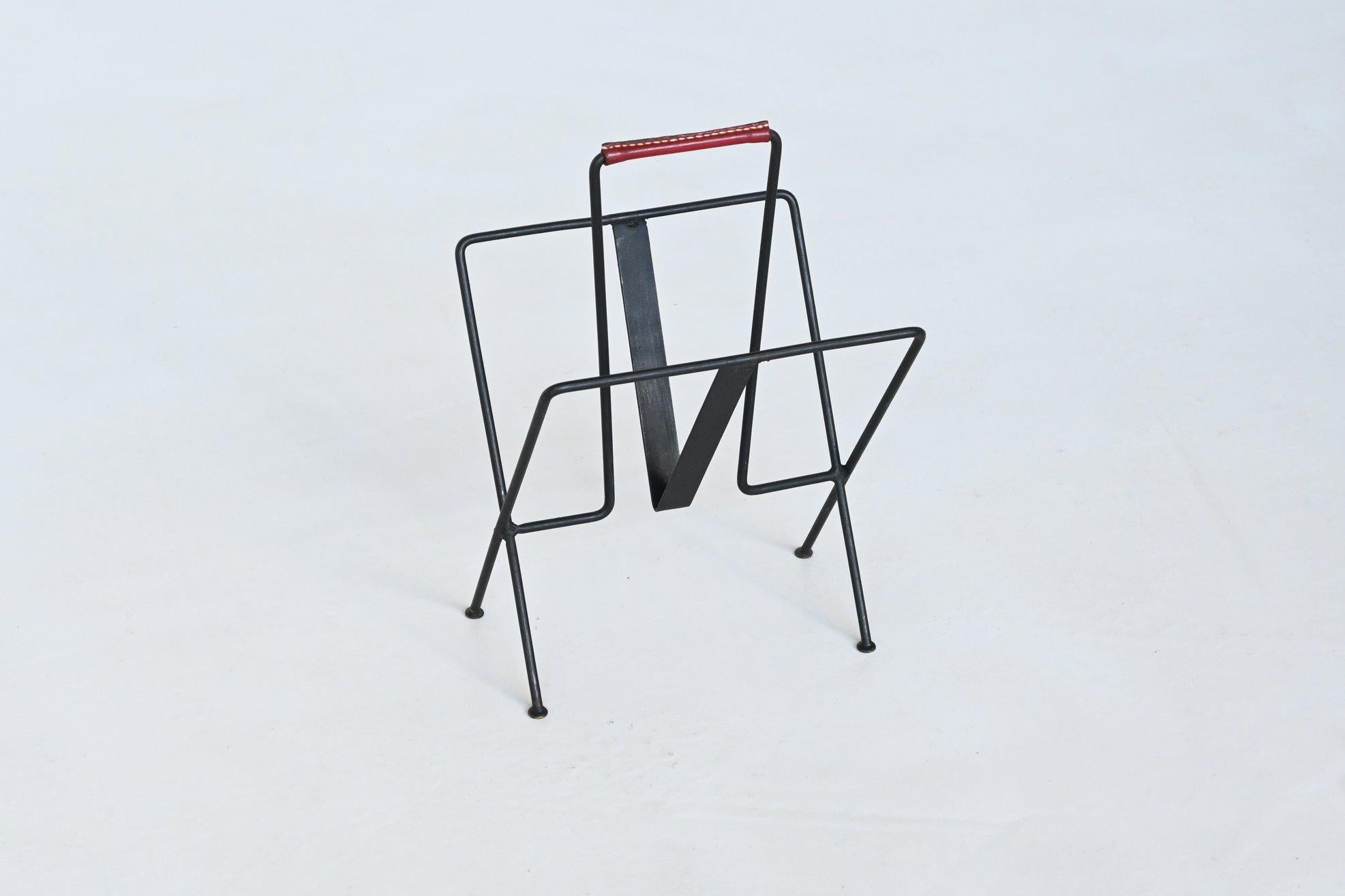 Very nice magazine stand designed by Jacques Adnet and manufactured in his own atelier, France 1950.  This highly decorative newspaper stand is made in original black lacquered metal decorated with a red handstitched Hermes Leather handle. The stand