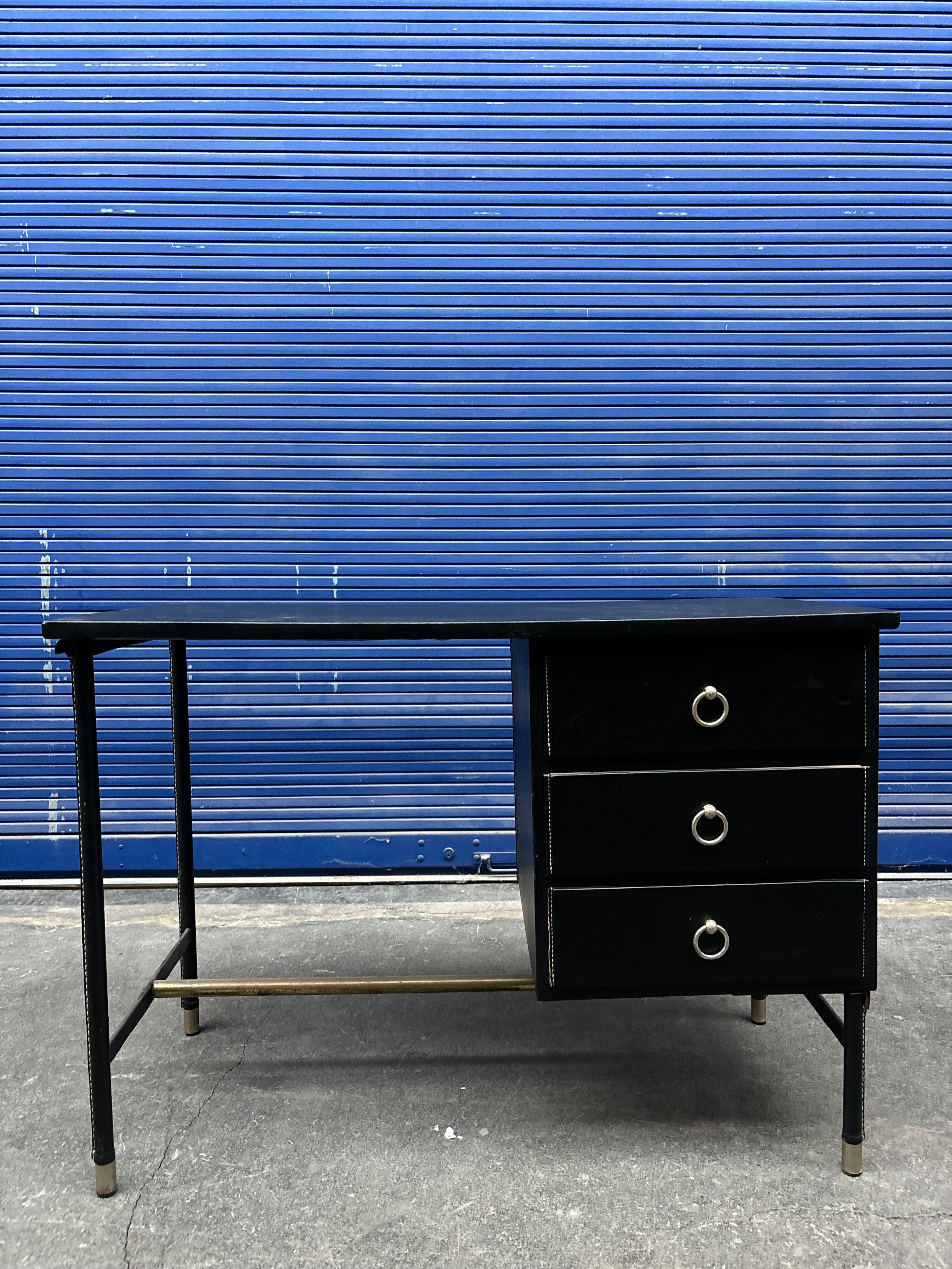 Raro bureau par Jacques Adnet en cuir piqué sellier. 