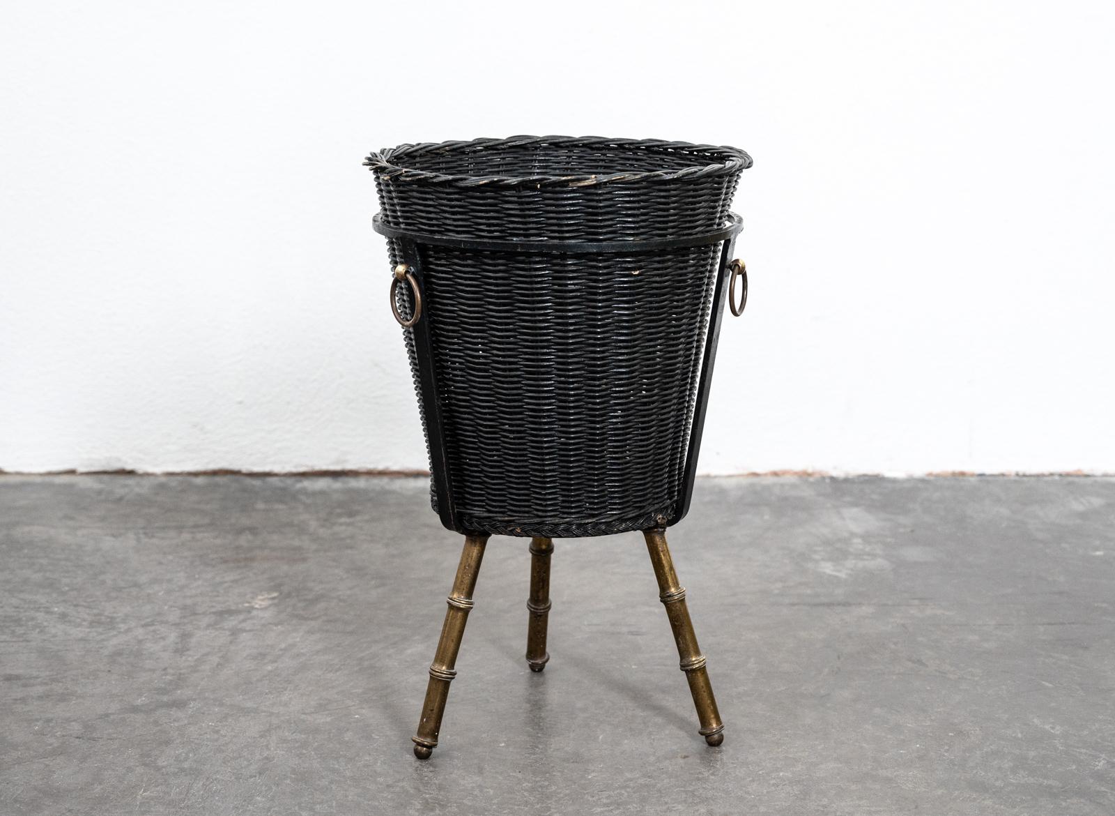 Rare midcentury rattan and steel wastepaper basket by Jacques Adnet with brass ring handles supported on three brass faux bamboo legs.