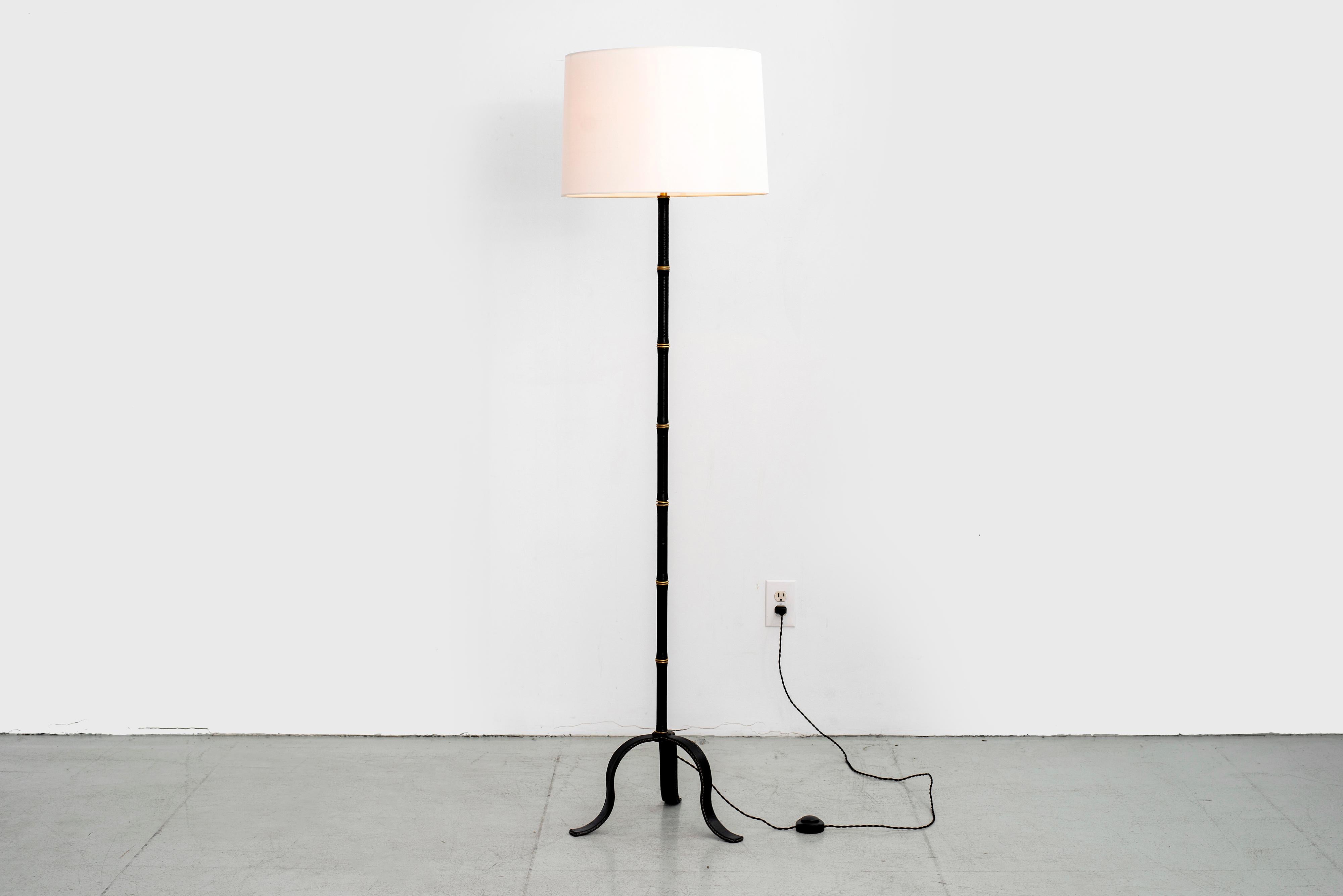 Incredible leather wrapped floor lamp with signature bamboo leather and brass stem and contrast stitching. Leather all the way down to the tripod base. 
Newly rewired with new silk shade.