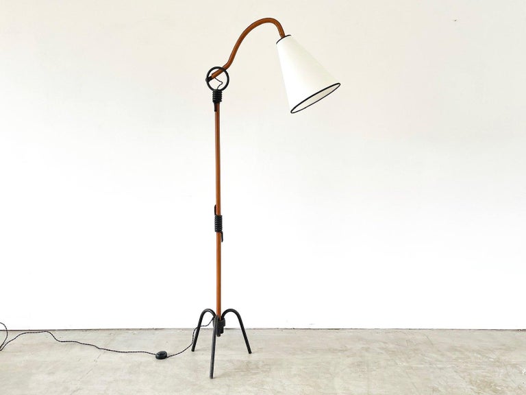 Jacques Adnet articulating floor lamp in caramel leather and iron tripod base.
Newly rewired and new shade with black contrast.