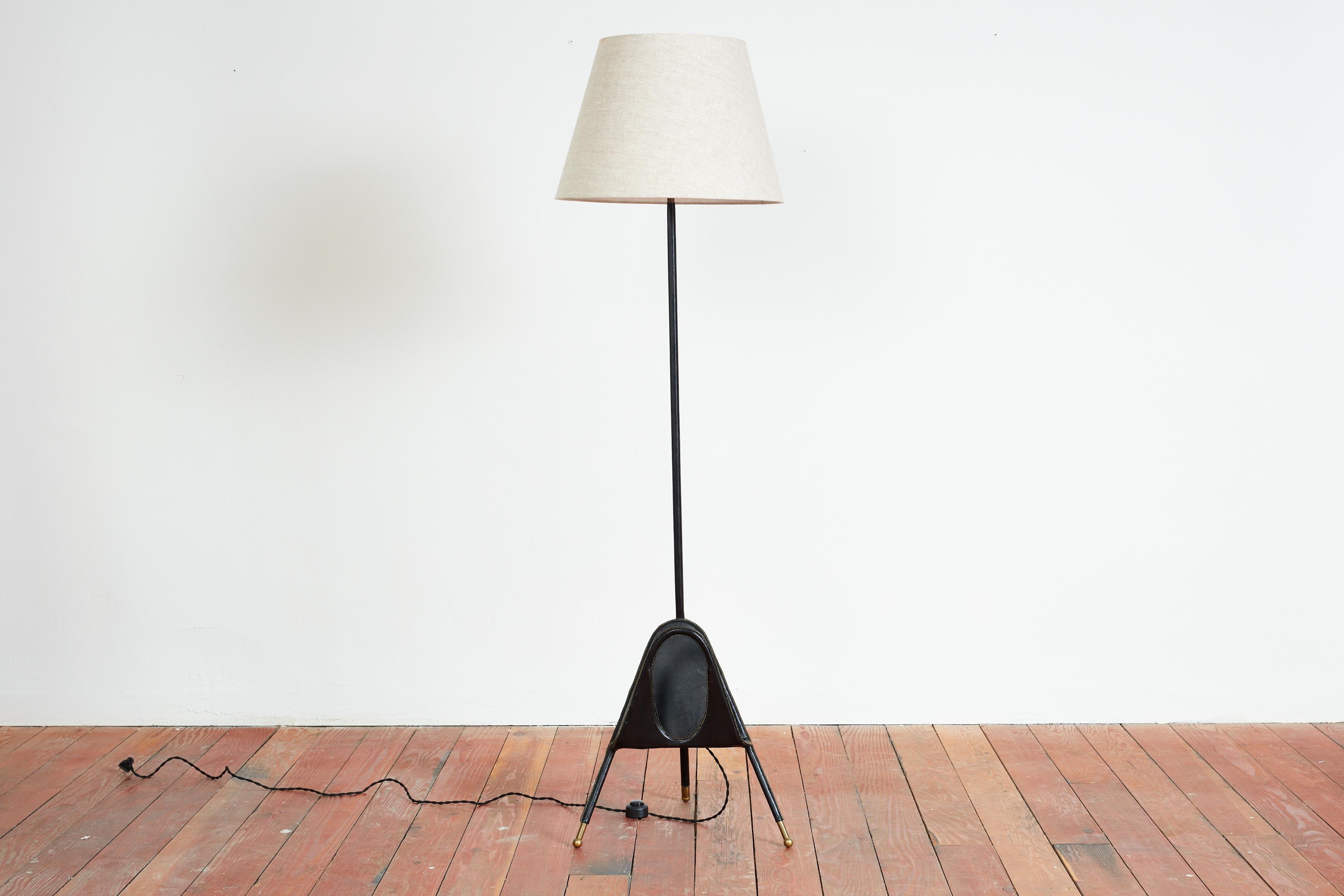 Uniques floor lamp by Jacques Adnet with attached magazine holder 
Unique cut out circle / shape 
Signature contrast stitching - original leather and new grey linen shade.