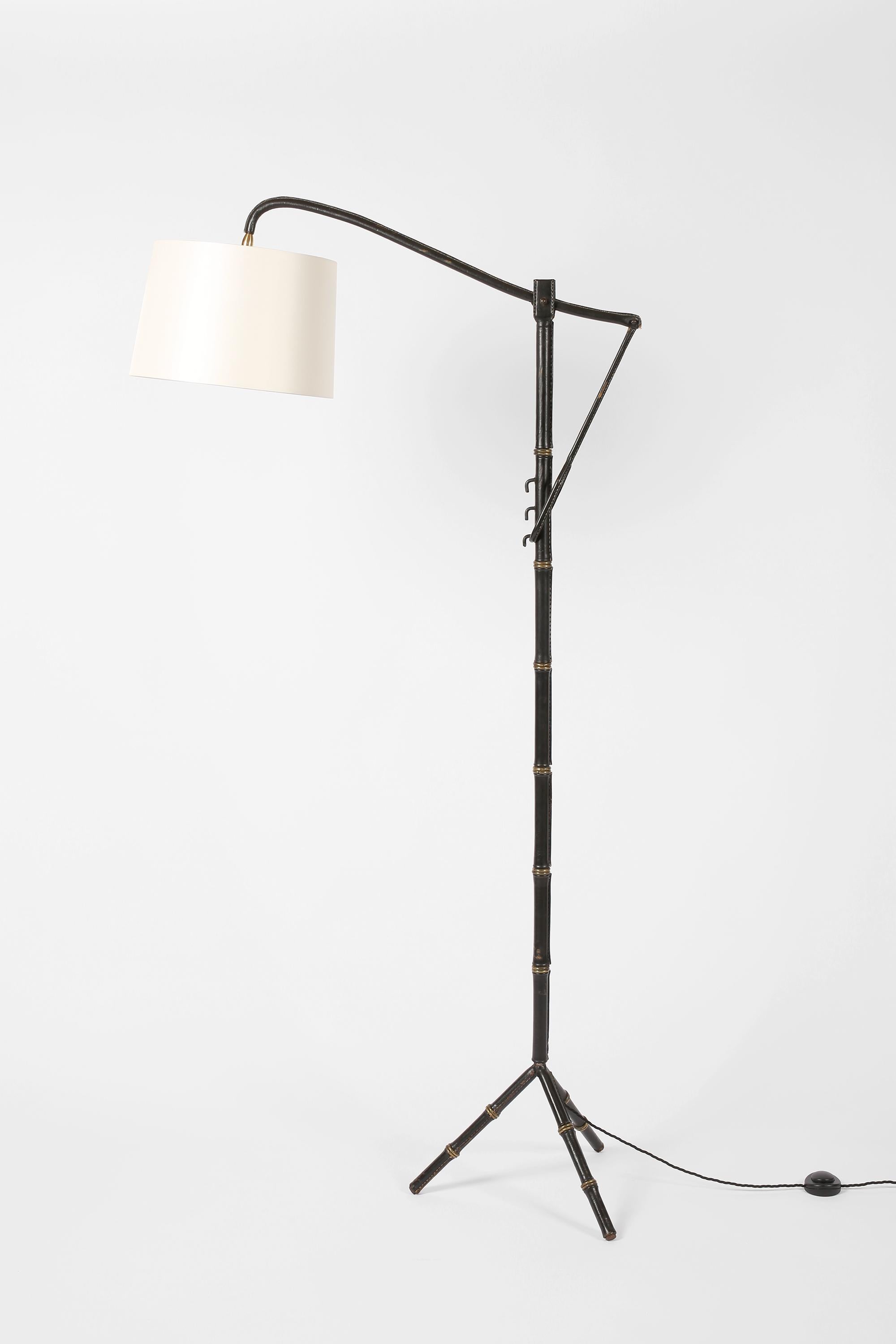 A rare black leather clad floor lamp by Jacques Adnet for Hermès, with gilt brass ring ‘bamboo’ detailing, contrast saddle stitching and unique ‘crémaillère’ height adjustment system. French, c. 1950.

Supplied with an off-white dupion silk shade