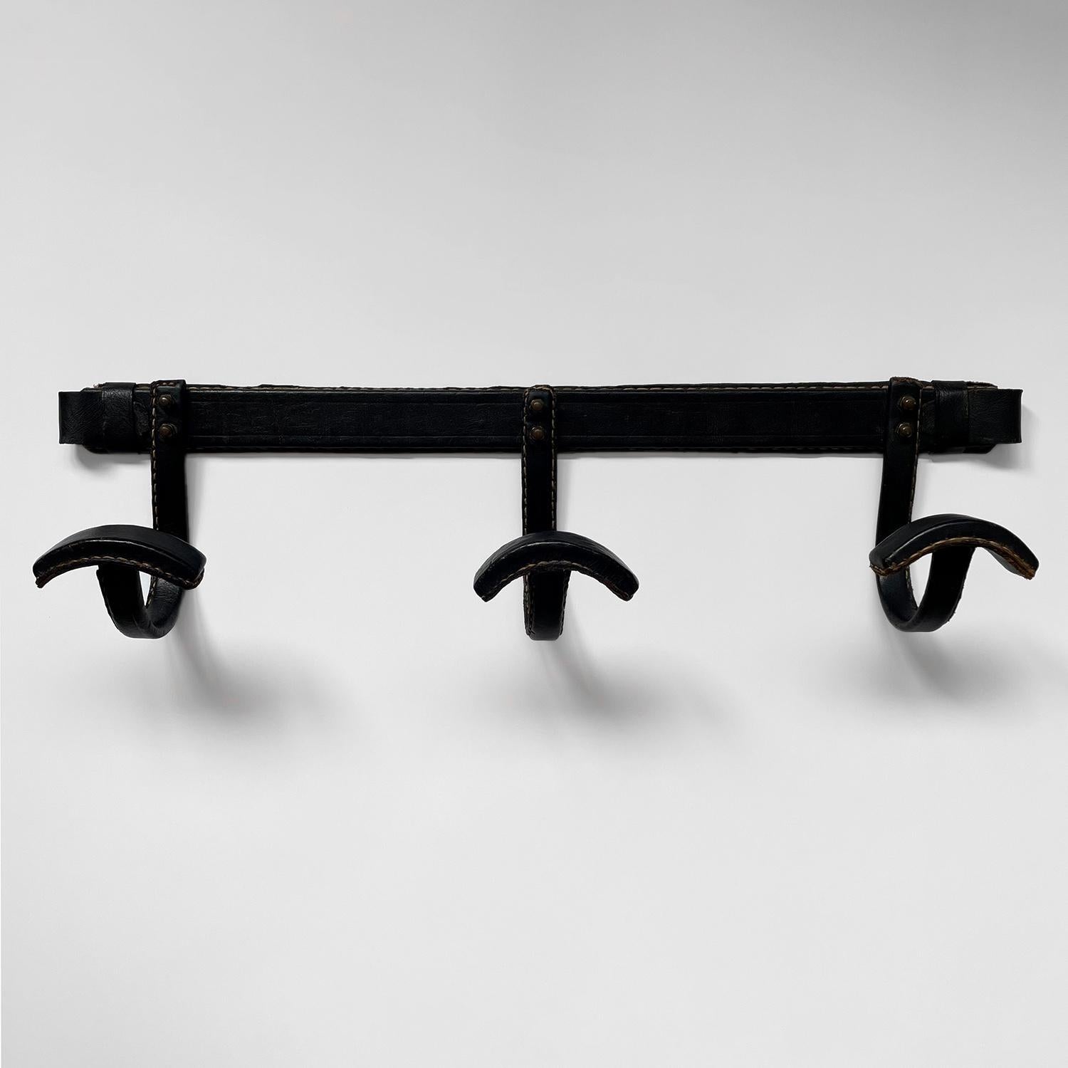 Jacques Adnet coat rack 
France, circa 1940’s
Black leather wrapped coat rack with signature contrast stitching
Three individual hooks each accented with double stud rivet detail
Beautifully worn in leather with minor loss and patina from age and