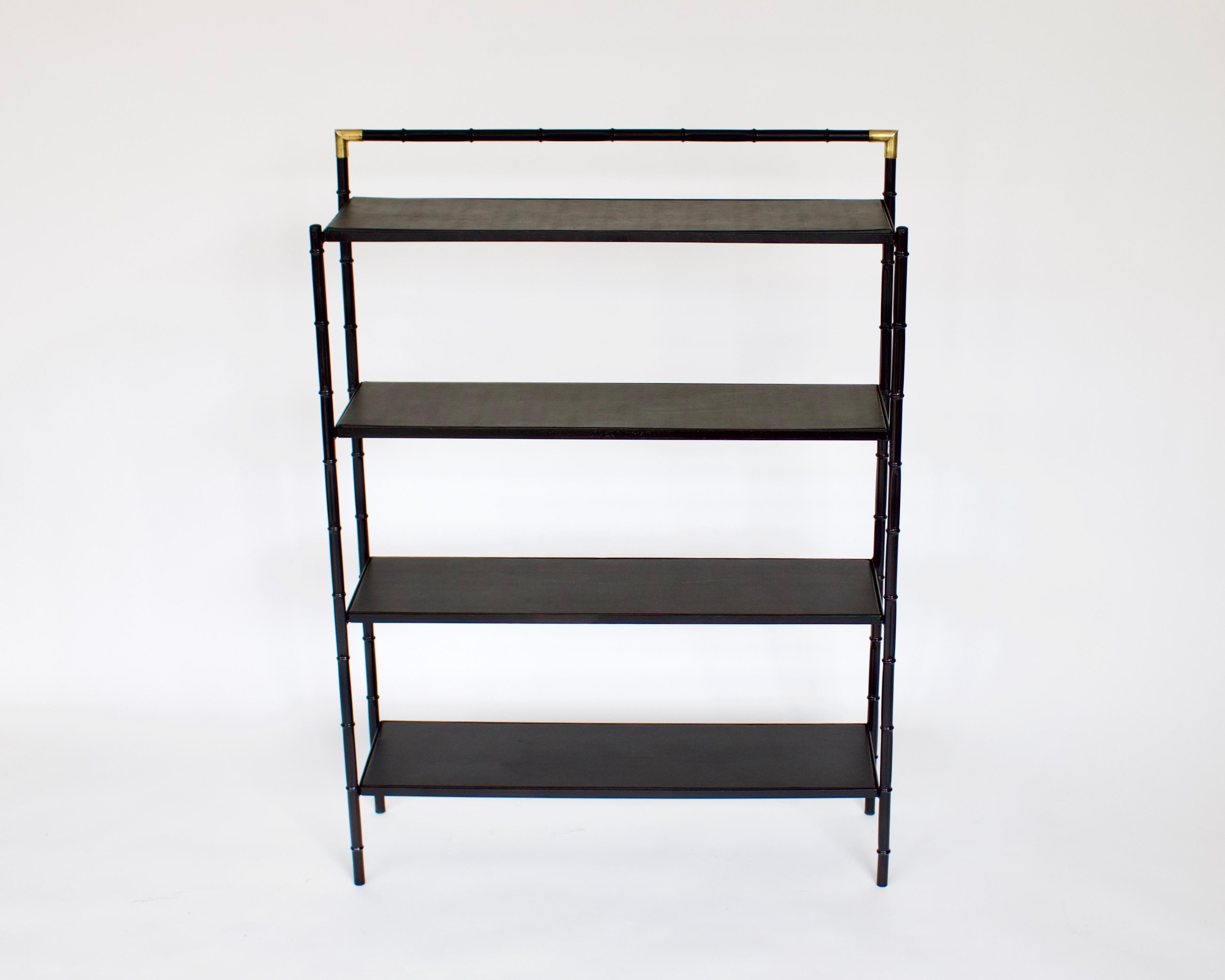Jacques Adnet French faux bamboo in metal and brass etagere or open bookshelf or display shelf with four shelves. The faux metal is lacquered black with brass corners.
Each shelf is covered in typical faux leather in very good condition.
All of