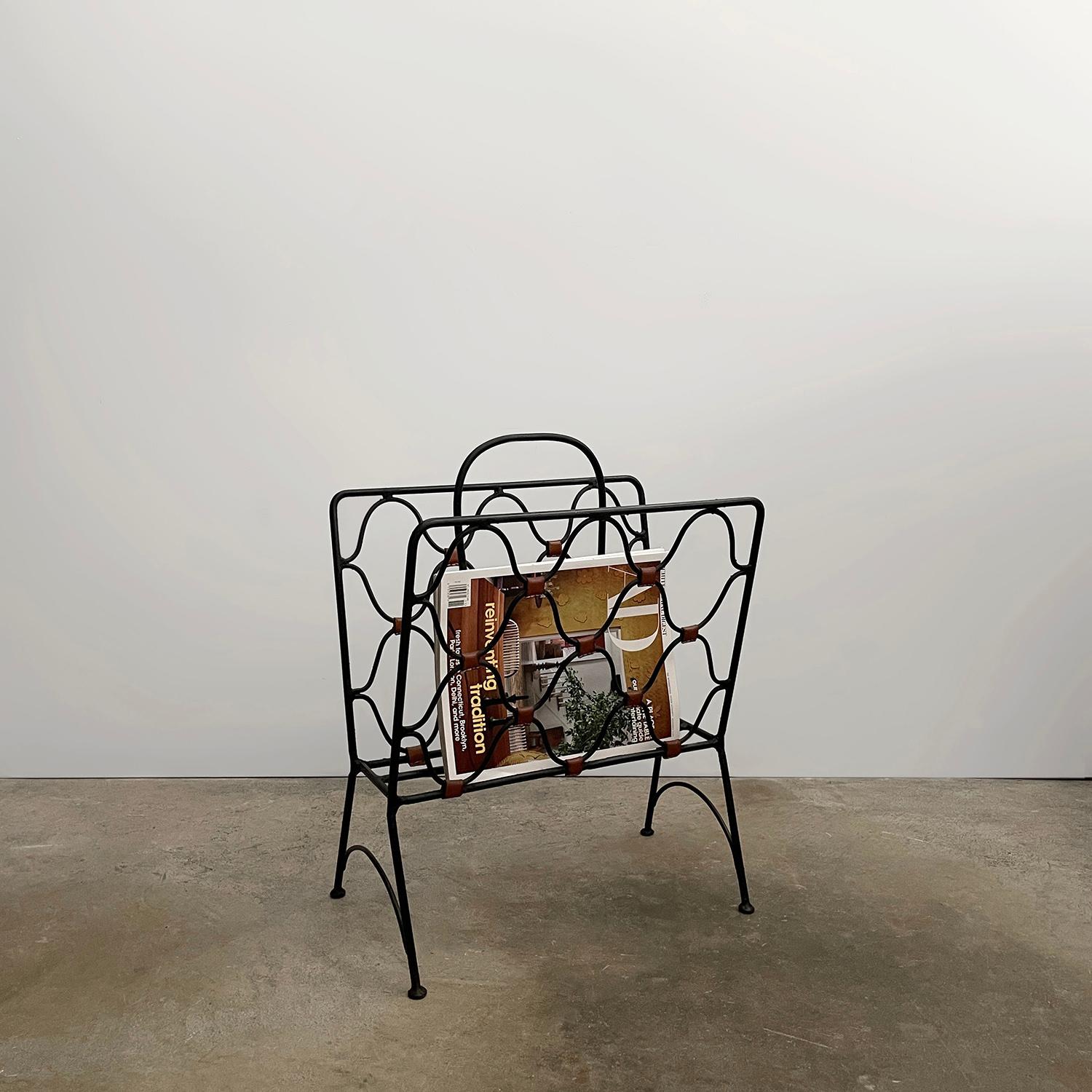 Portariviste in ferro e pelle di Jacques Adnet
Francia, anni '50 
Questo classico senza tempo è un'opera d'arte.
Telaio in ferro massiccio con intricati dettagli ad anello, arricchito da una ricca pelle di cuoio e da cuciture a contrasto.
Patina