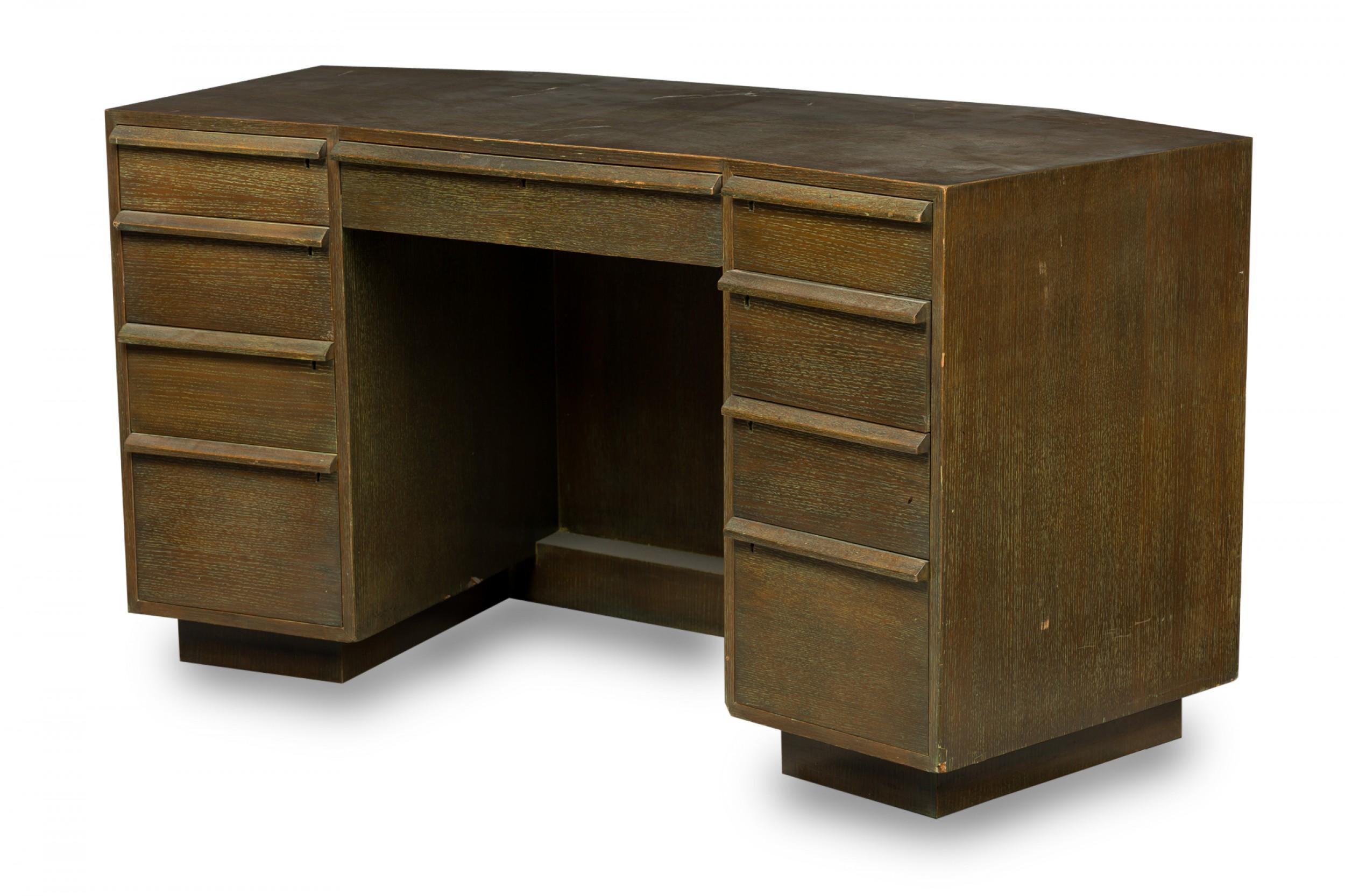 French midcentury cerused oak kneehole desk with a central drawer flanked on either side by a column of four drawers, with wooden top-mounted drawer pulls. (Attributed to Jacques Adnet).