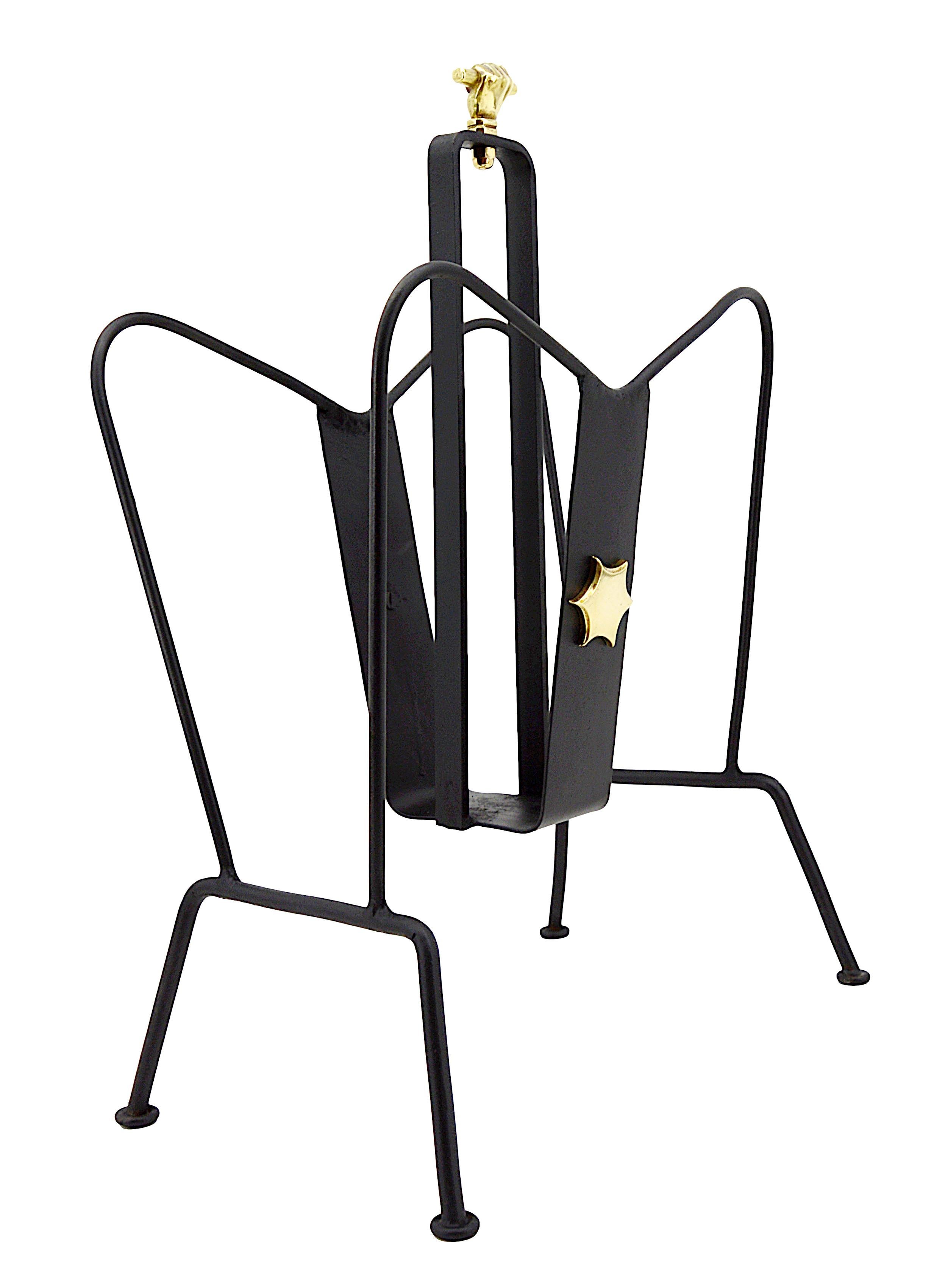 French mid-century magazine rack by Jacques Adnet for Perrier & Fils (Paris), France, 1950s. Magazine rack in wrought iron and gilded brass with two compartments and base with pastille base. Handle adorned with a gilt brass hand. Each side upright