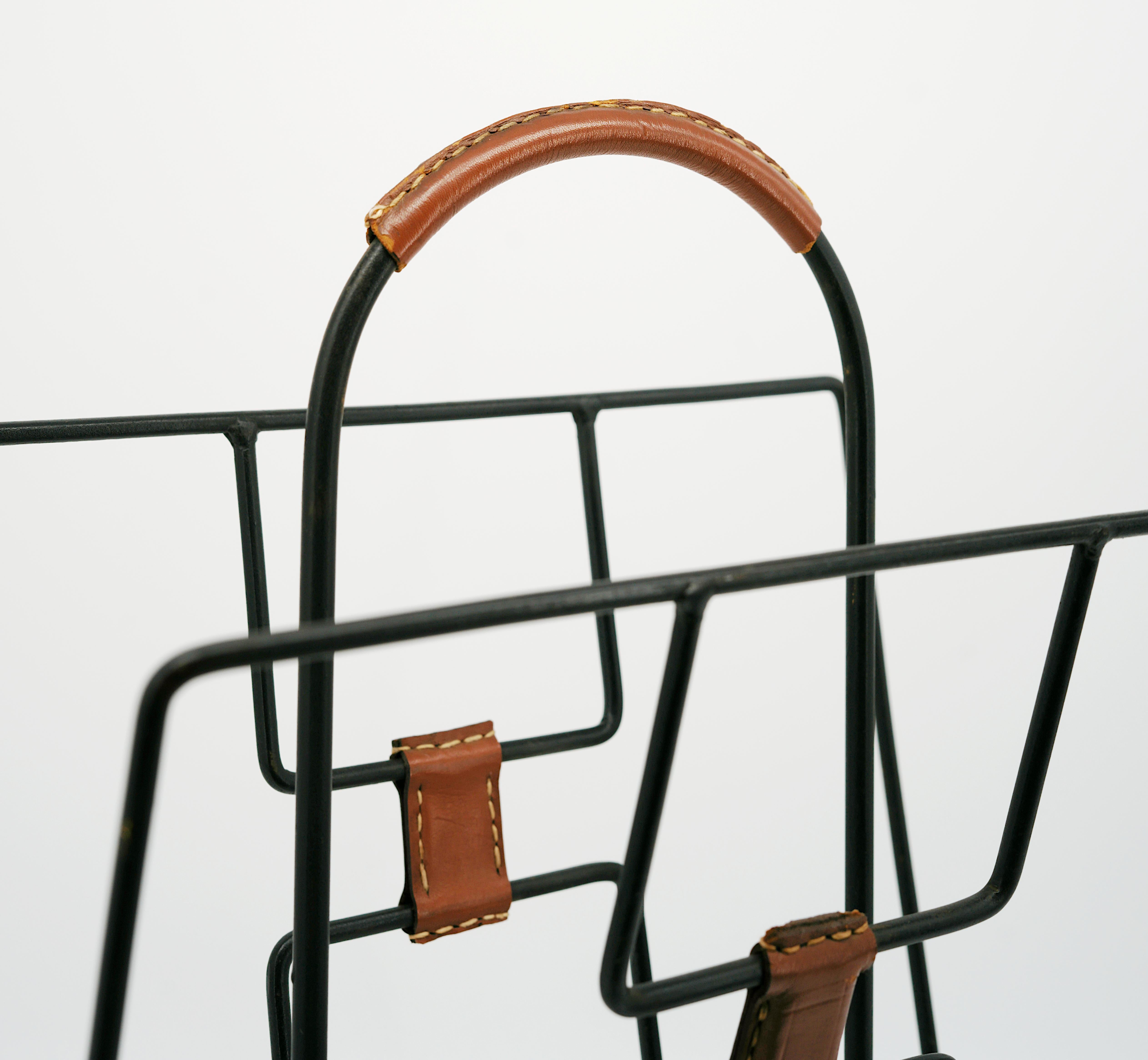 French Mid-century magazine rack by Jacques ADNET, France, 1950s. Magazine rack in leather and iron with two compartments and pastille base. Height : 16.25