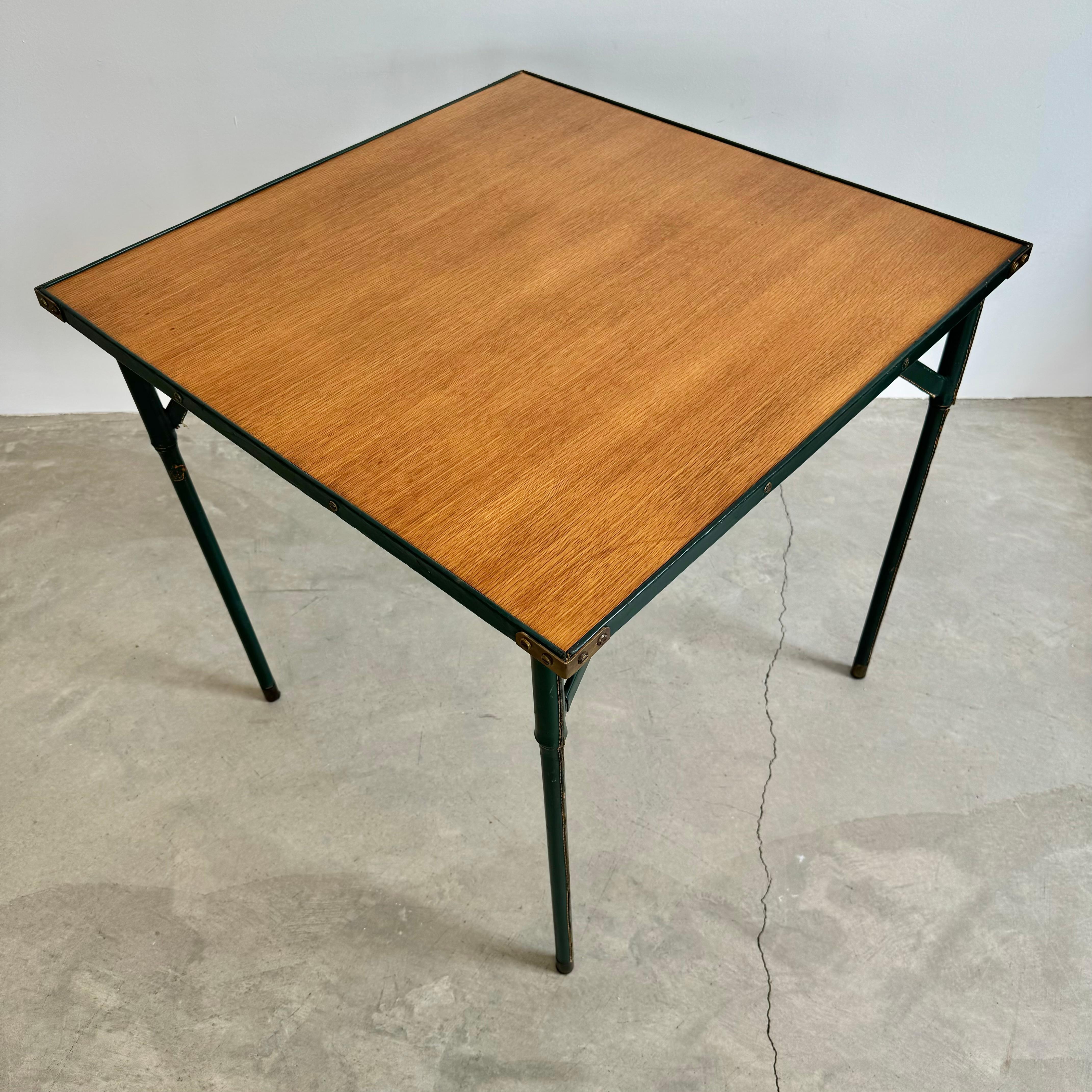 Stunning leather table by French designer Jacques Adnet. Green leather wrapped bamboo style legs with leather wrapped top and corners. Original wood tabletop. Brass detailing throughout. Signature Adnet contrast stitching throughout. Great vintage
