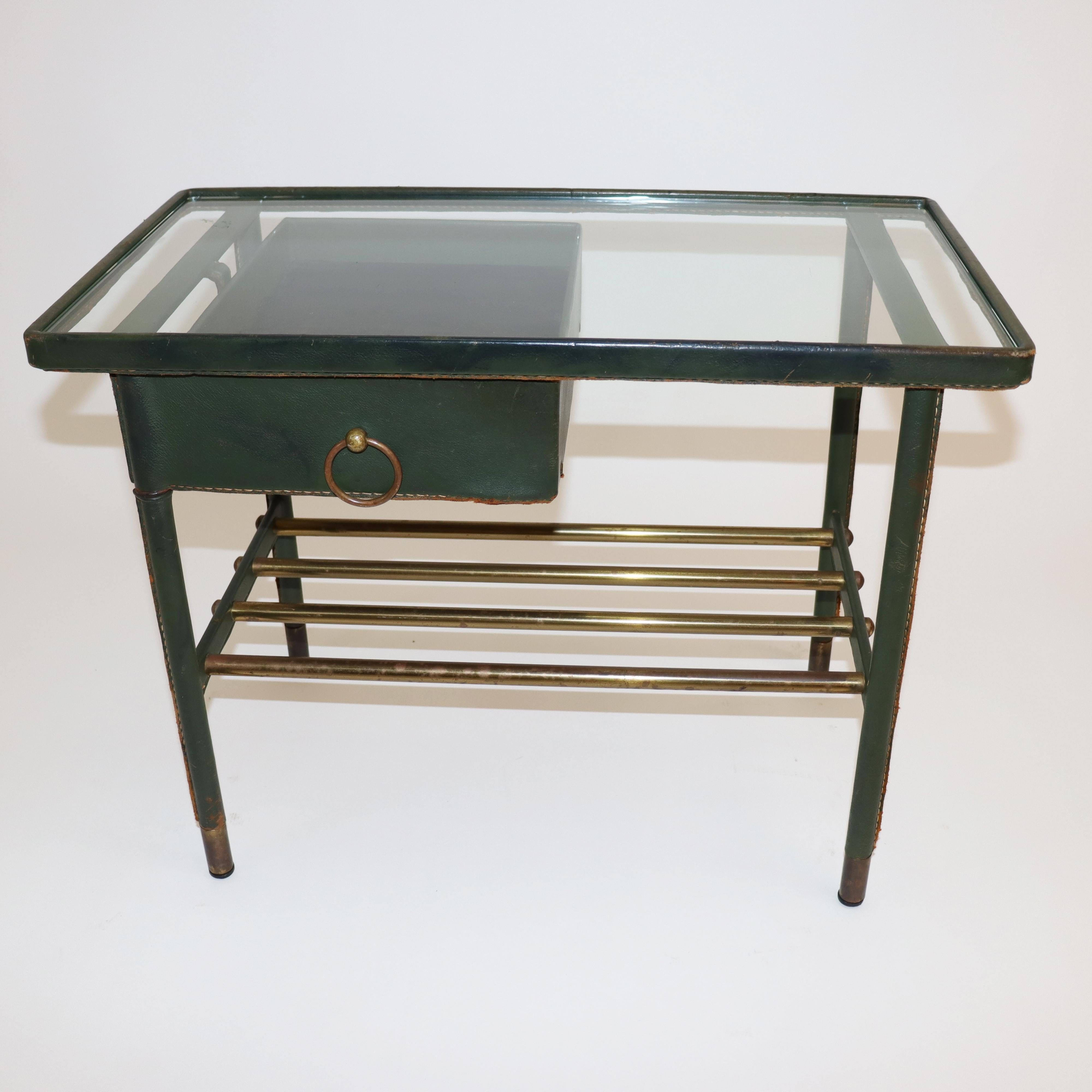 Jacques Adnet handstitched green leather nightstand
nightstand, side table with glass top and swivel drawer with organizer tray,
brass pull ring. Wrapped in green handstitched leather 
Brass capped feet. Good original condition.