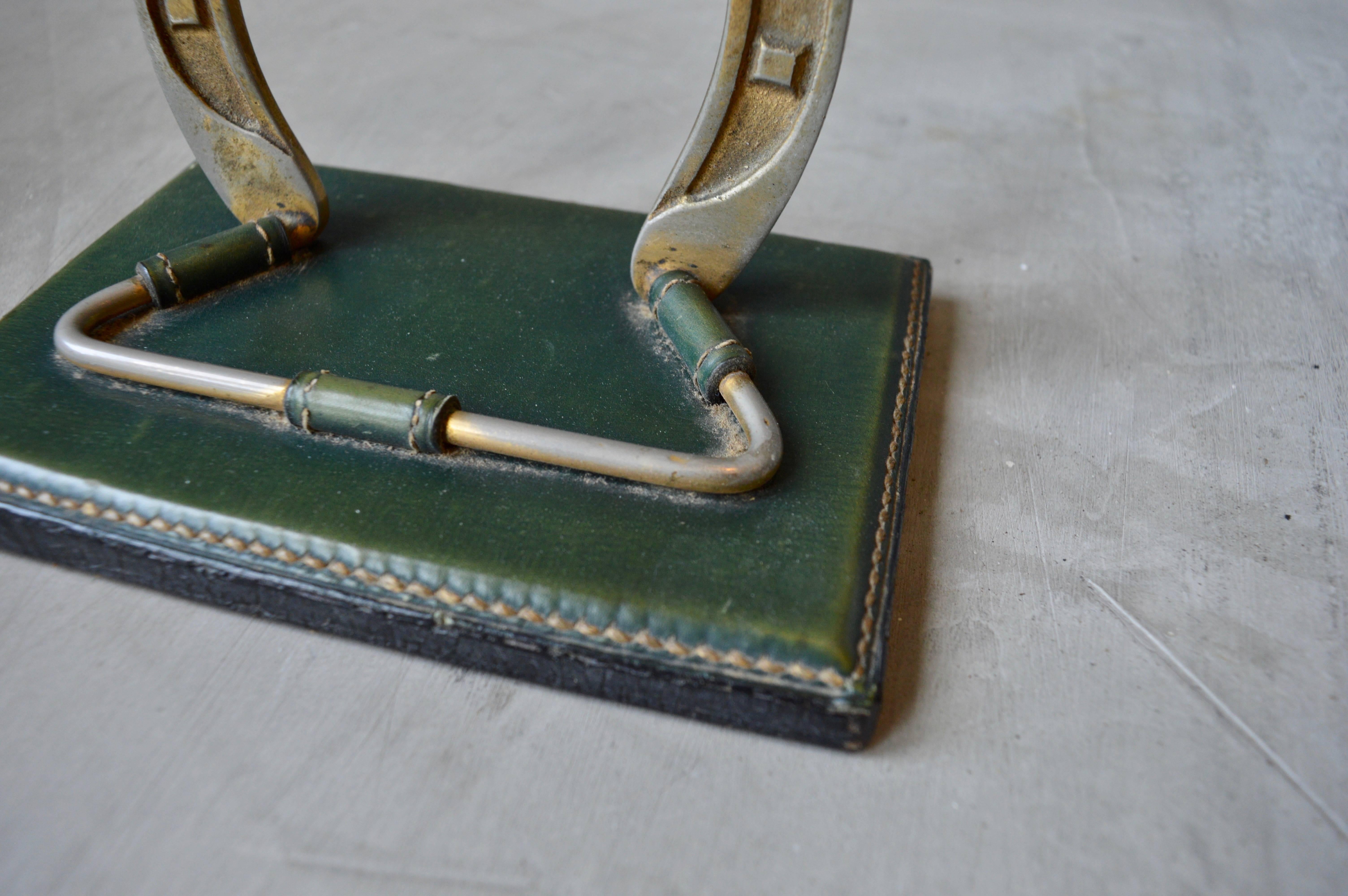 Elegant green leather jewelry tree by Jacques Adnet. Brass horseshoe on green leather base with signature Adnet contrast stitching. Great for placing necklaces and rings. Multifunctional piece. Excellent vintage condition.