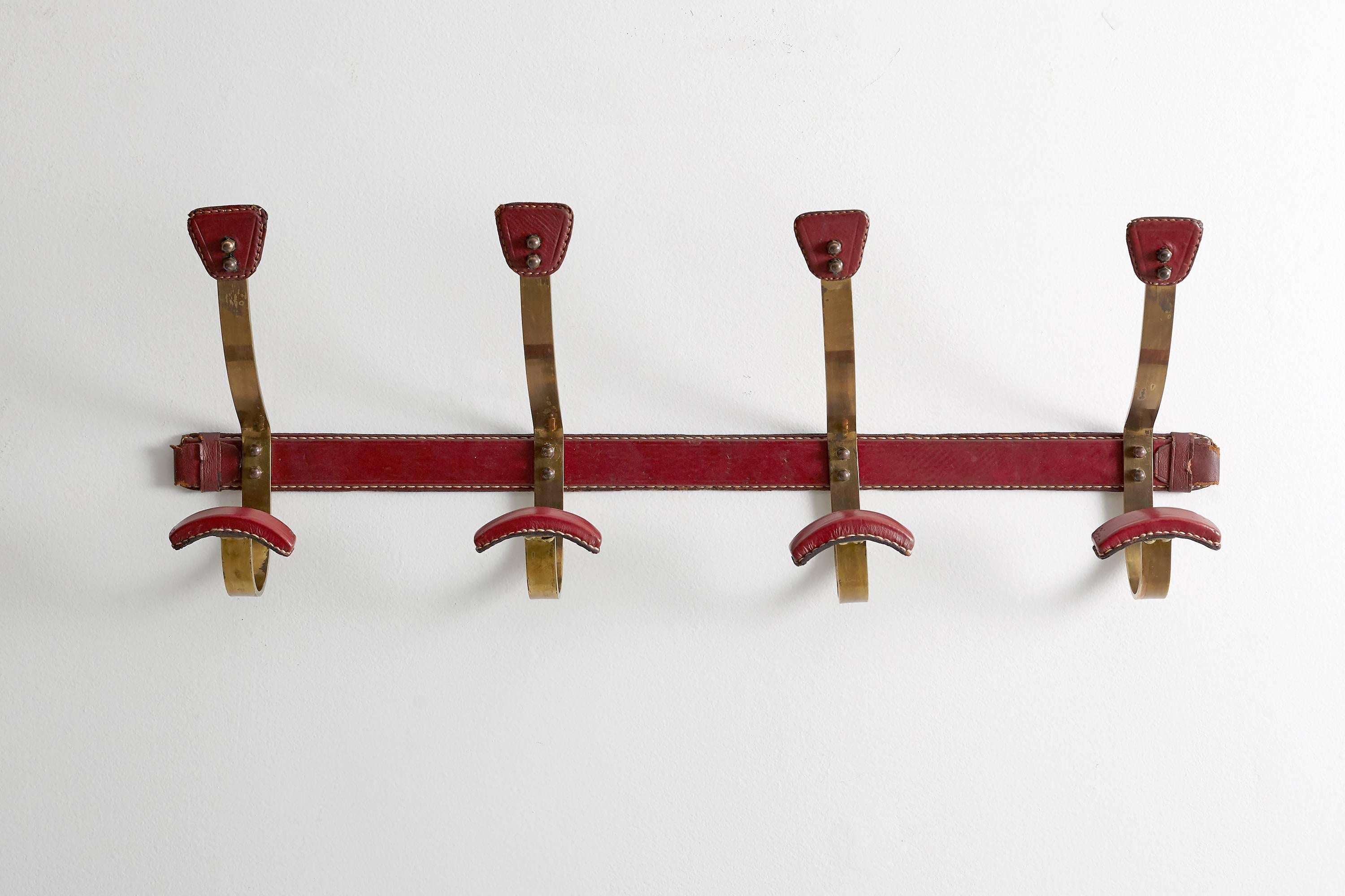 Rich red leather wrapped brass coat rack with signature Adnet leather and contrast stitching.