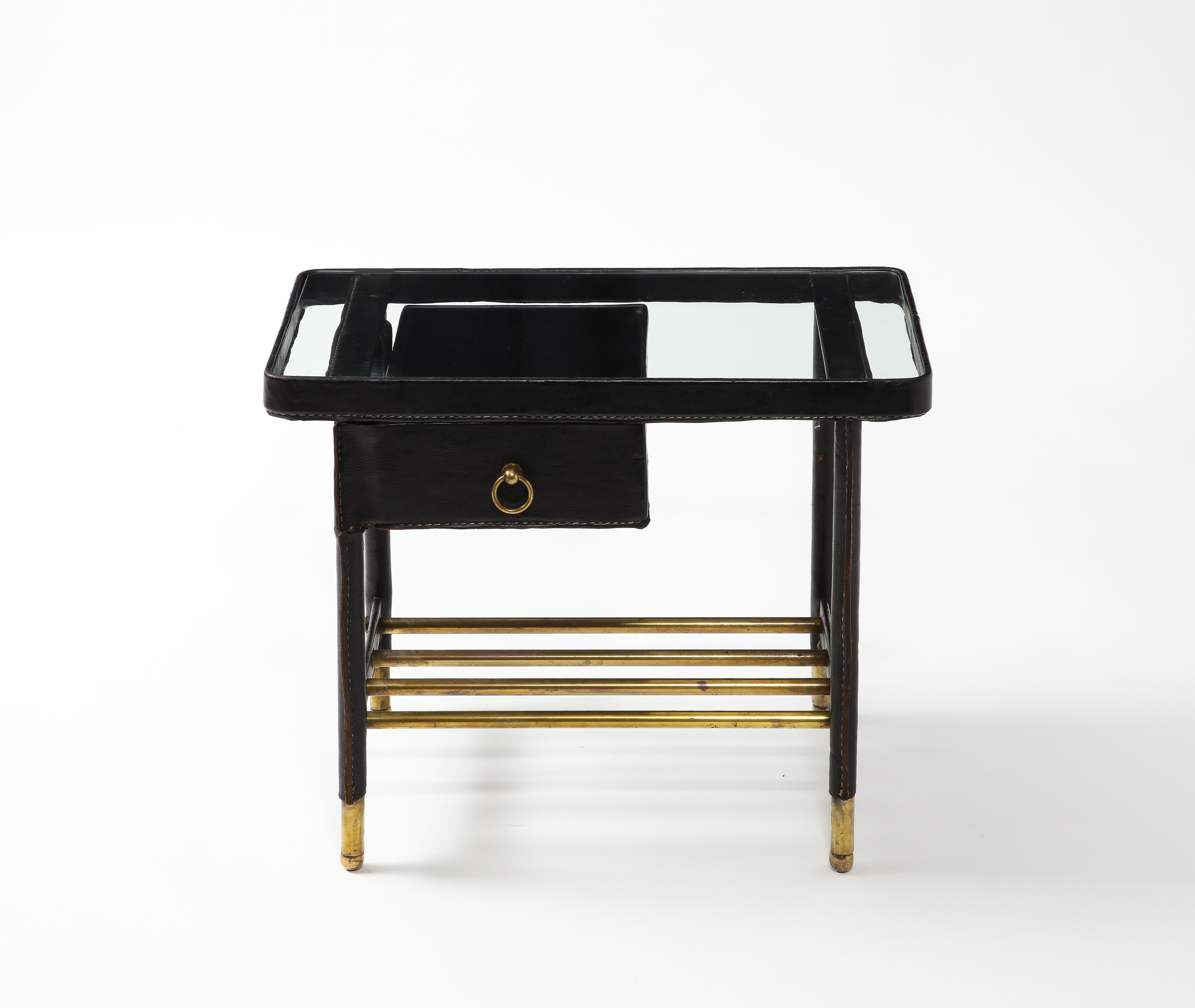 End table in leather and brass with a glass top and a drawer that swivels out.