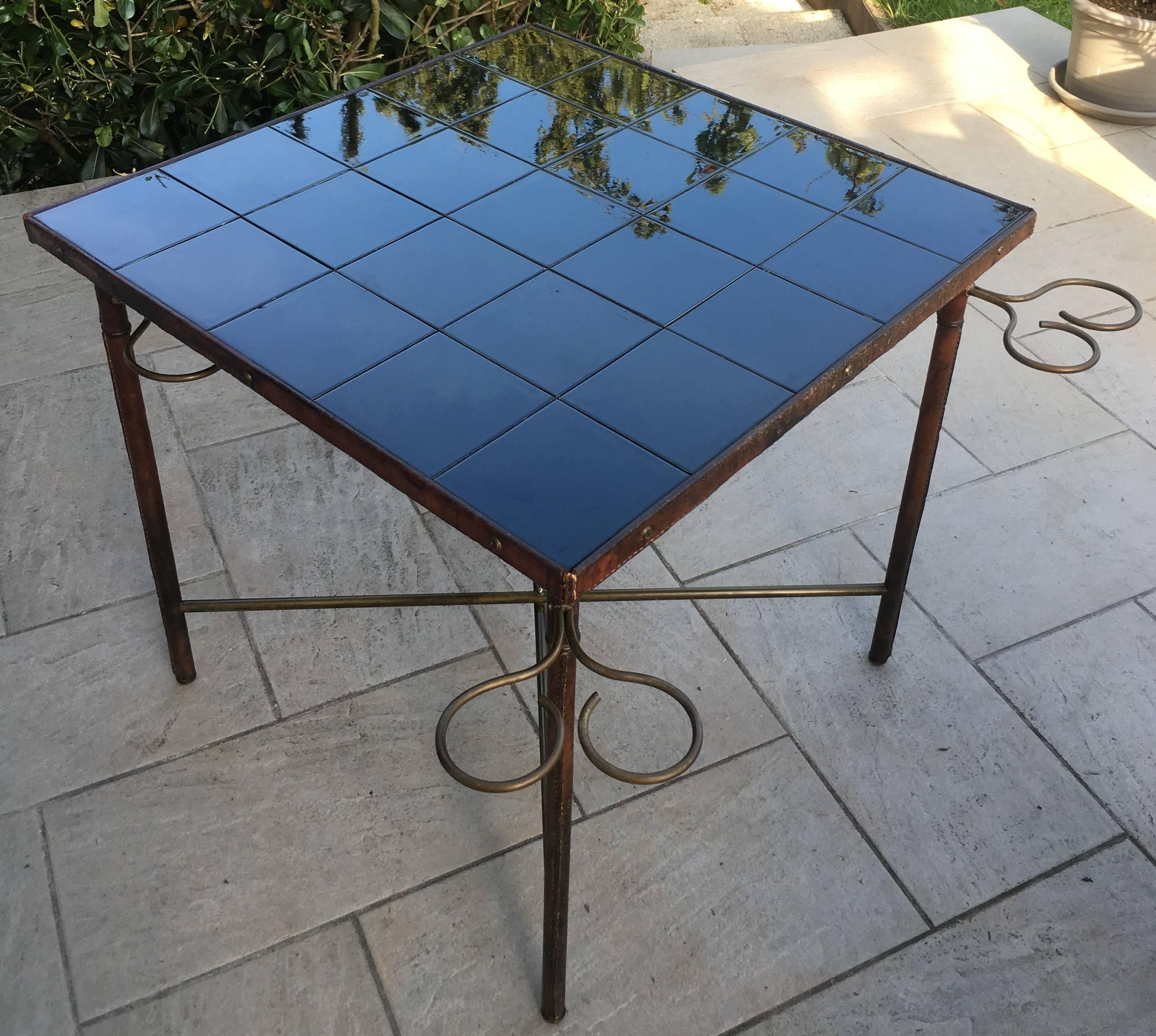 Hand-stitched brown leather occasional or game table designed by French designer Jacques Adnet.
Probably made for a private order, it comes from a property in the south of France. A similar model exists with a top covered in faux leather, seen 20