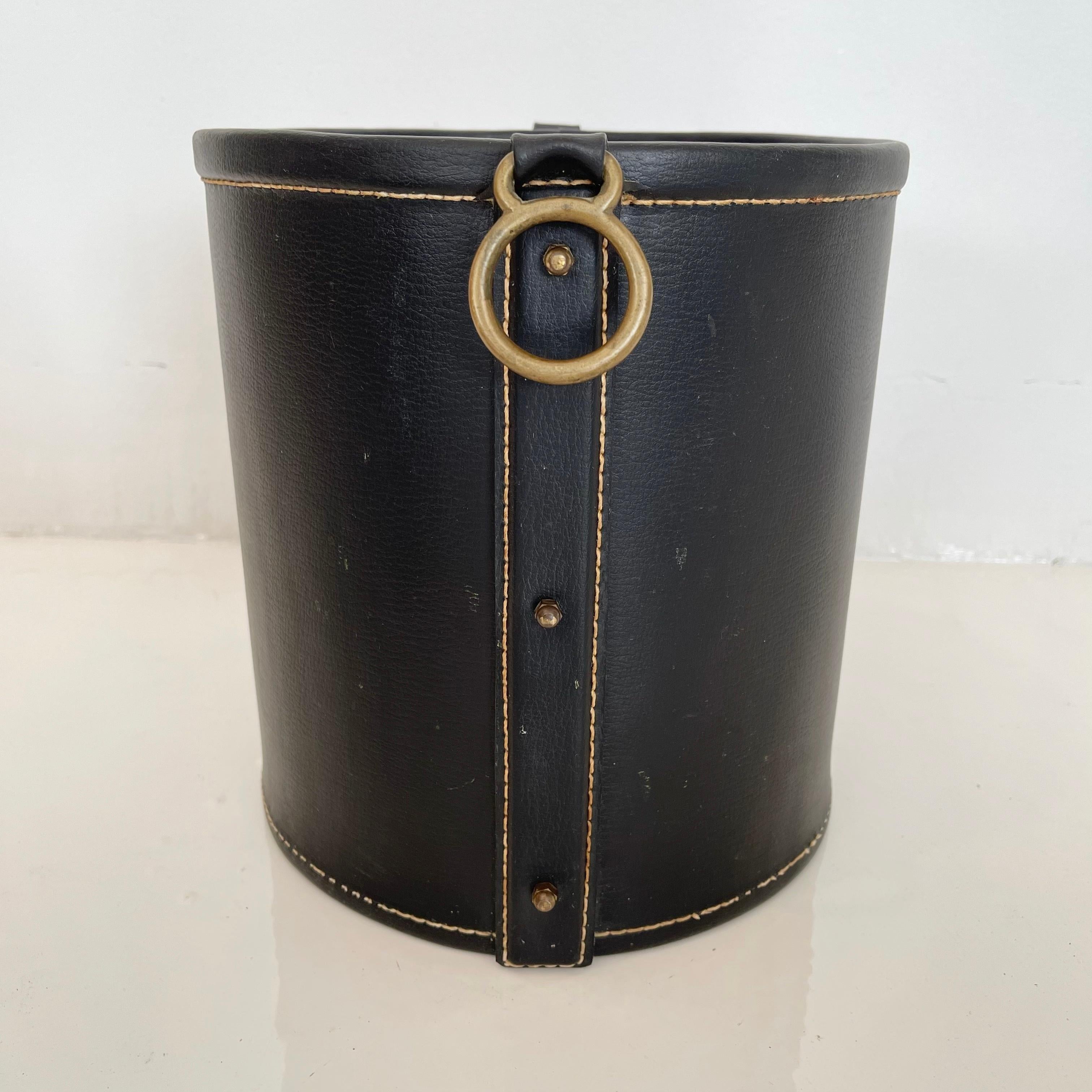 Handsome leather and brass waste basket by French designer Jacques Adnet. Excellent condition and patina to leather and brass. Wood bottom. Very sturdy. Great lines. Collectible piece of Adnet design.