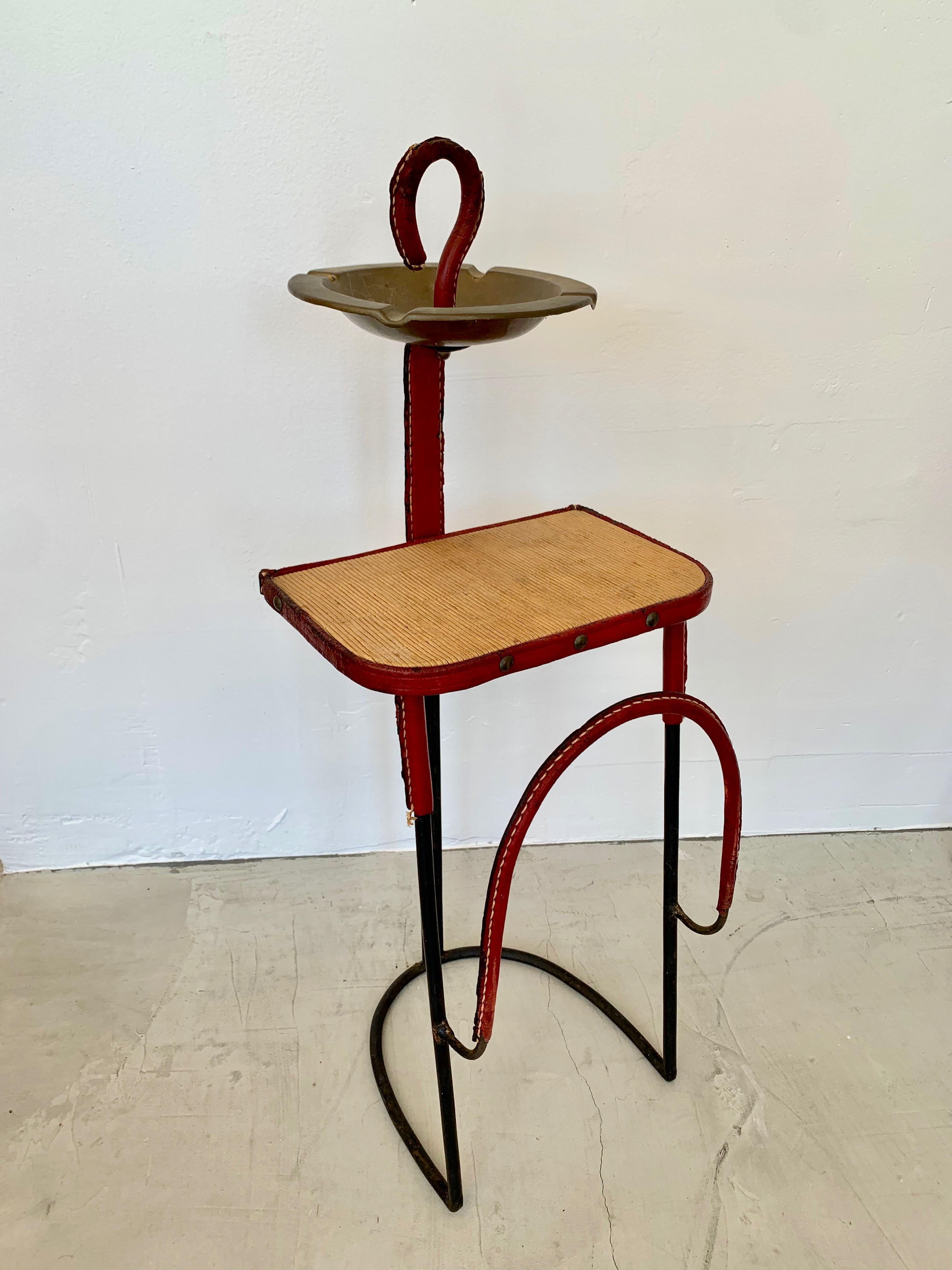 Very unusual 3 in 1 side table by Jacques Adnet. Iron frame with leather wrapped trim. Wood side table wrapped in leather. Magazine rack on the front. And brass ashtray or catchall at the top. Great sculptural piece and excellent example of Adnet